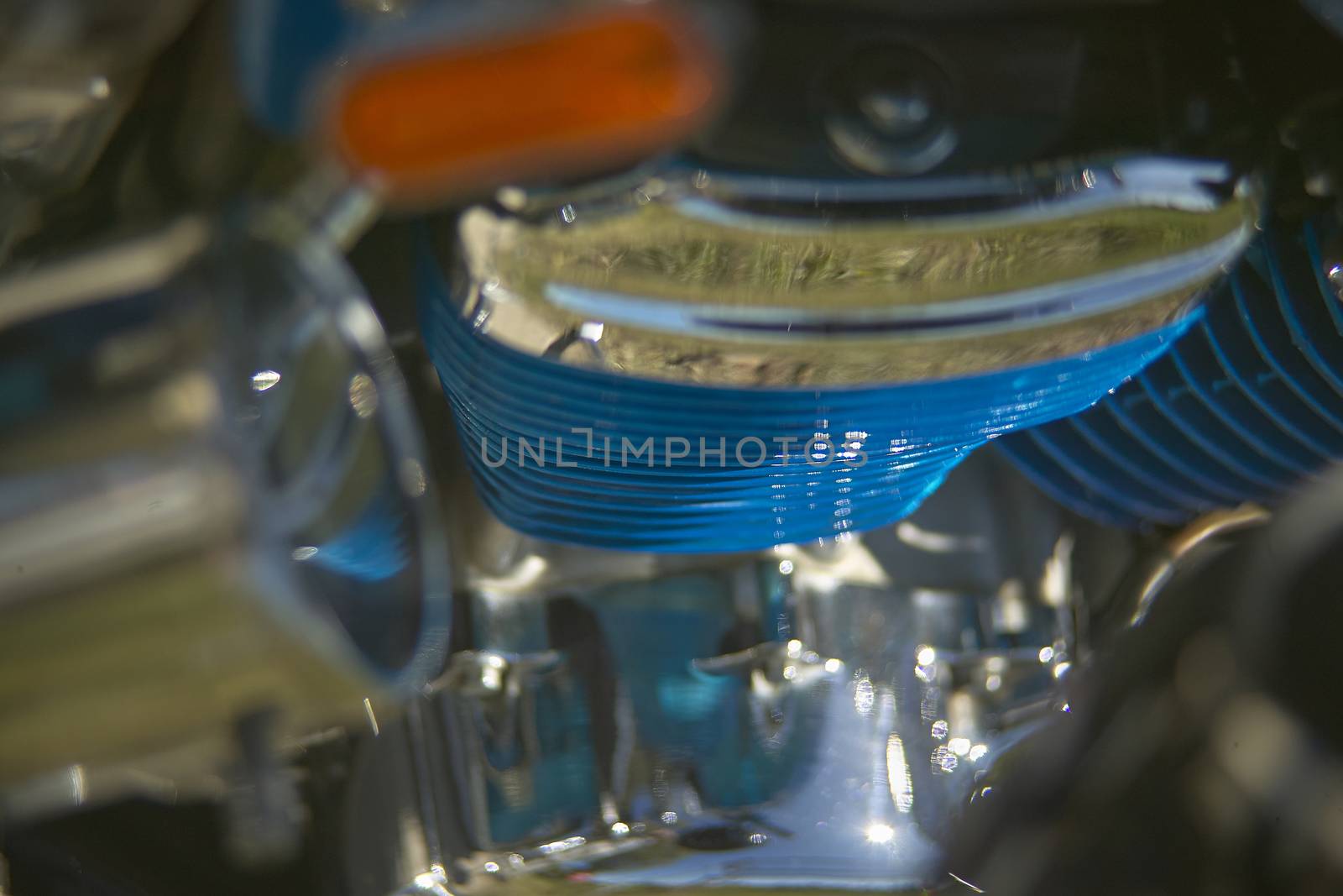 Engine of a colorful custom blue motorcycle, with glittering chromes, a symbol of how much passion can lead to detailing.