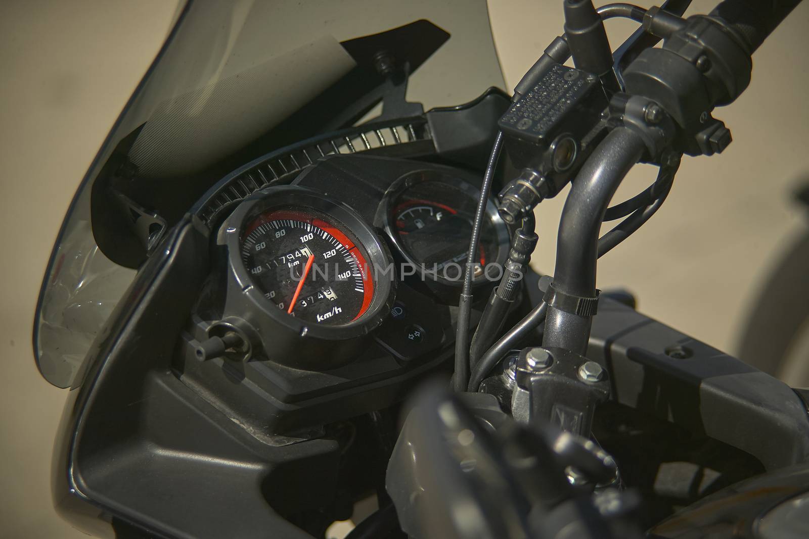 speedometer of a modern enduro bike, detail of the instrument cluster with a handlebars and a well-visible brake pump.