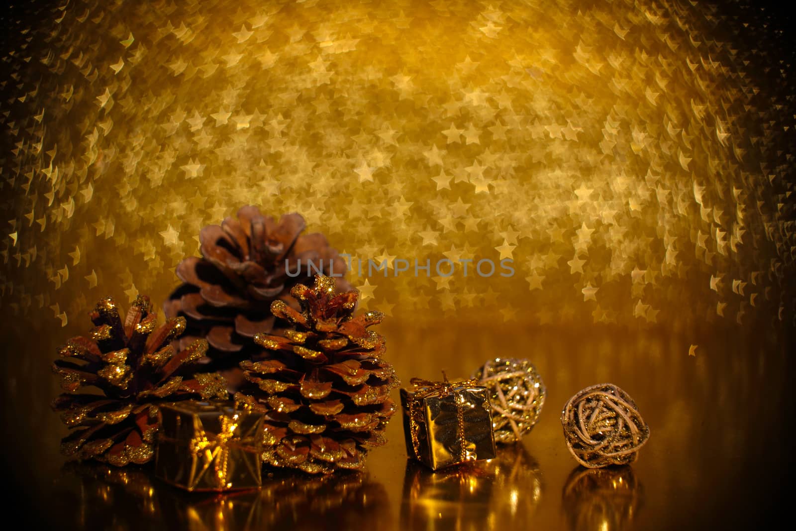 Christmas decoration of pine cones and decorative gifts golden star bokeh background