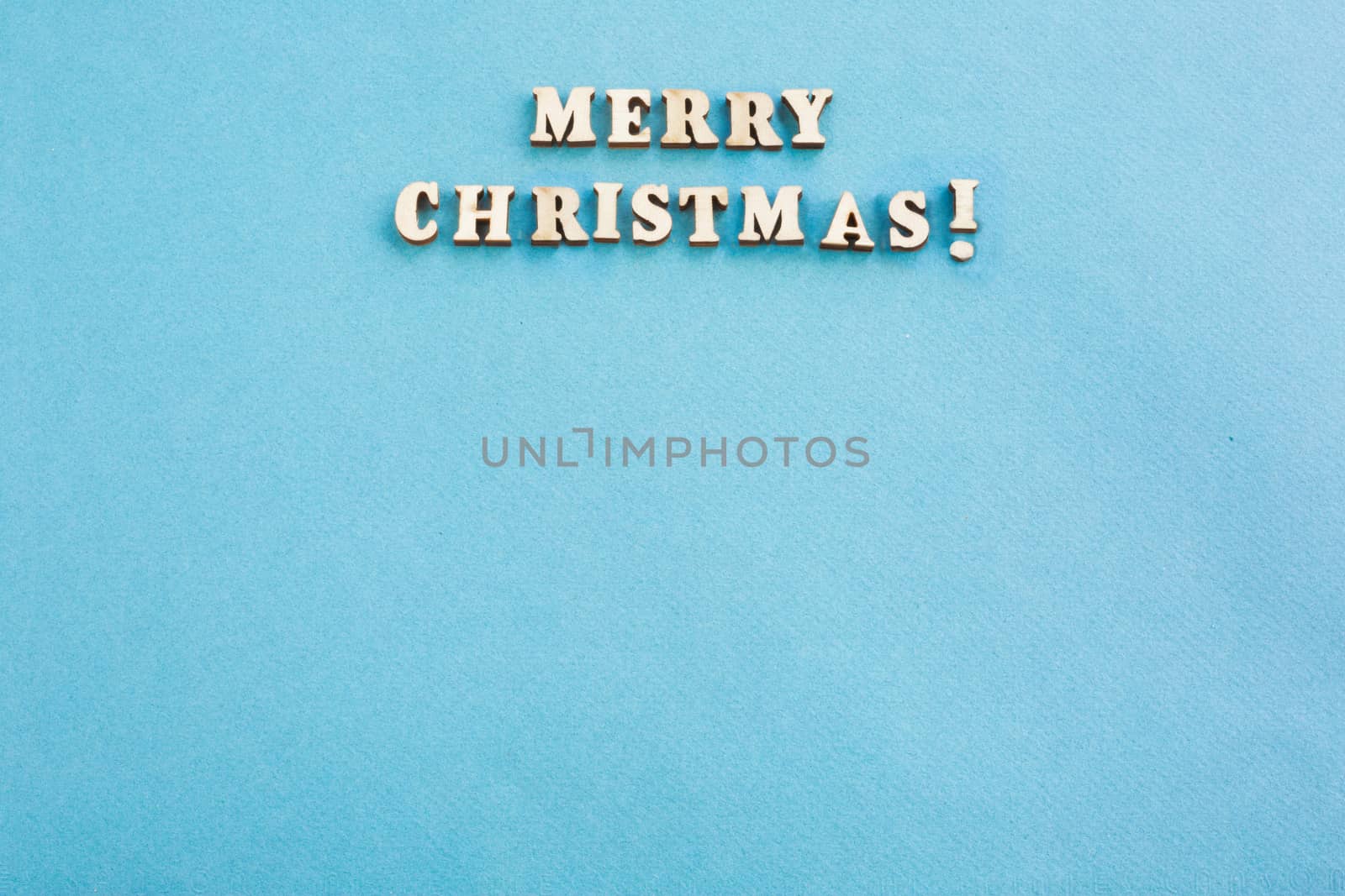 Merry Christmas sign small wooden decor on blue paper card background