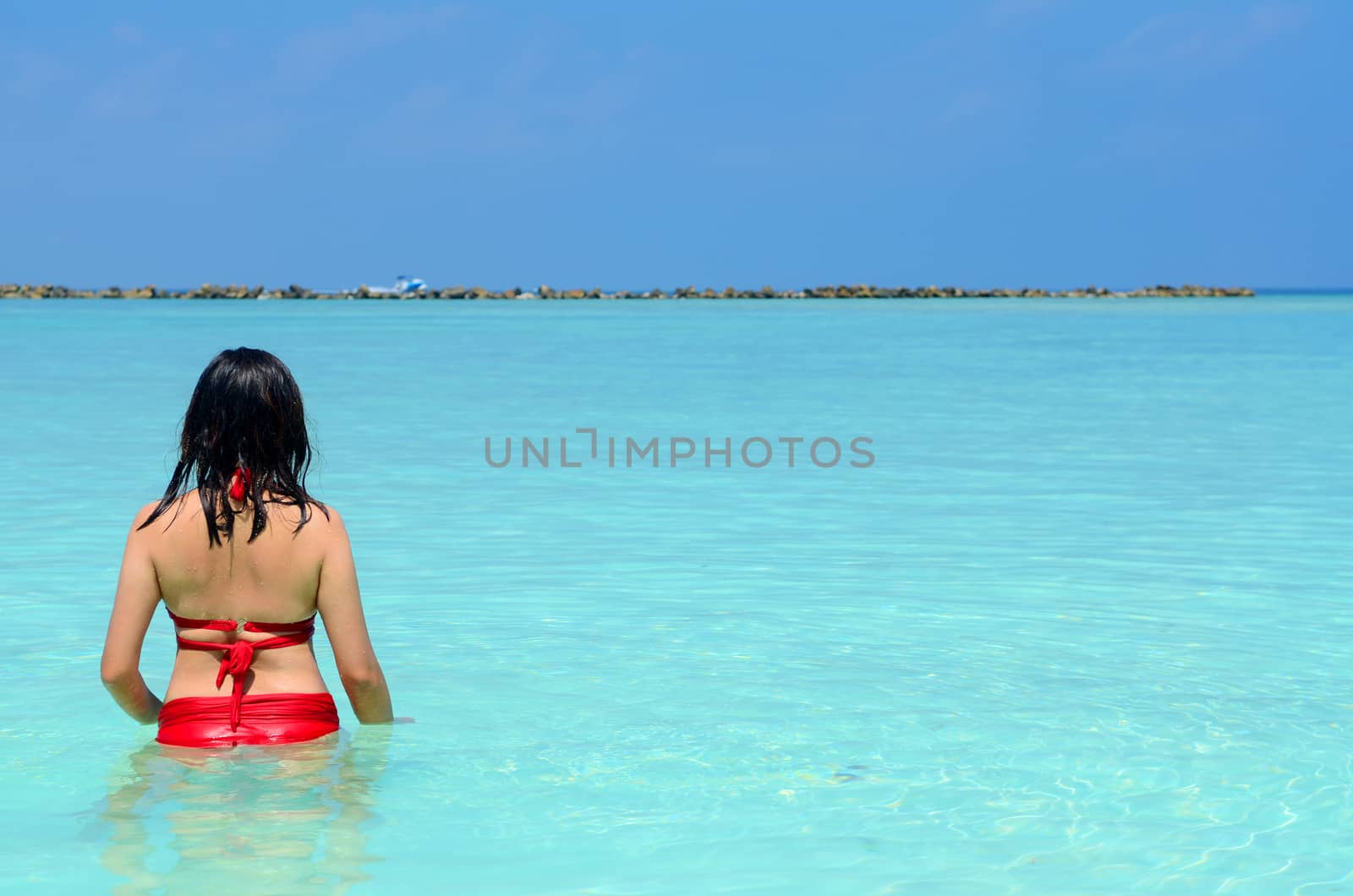 Woman relax in the crystal-blue sea of tropical beach at  Maldives islands. Happy lifestyle concept. 