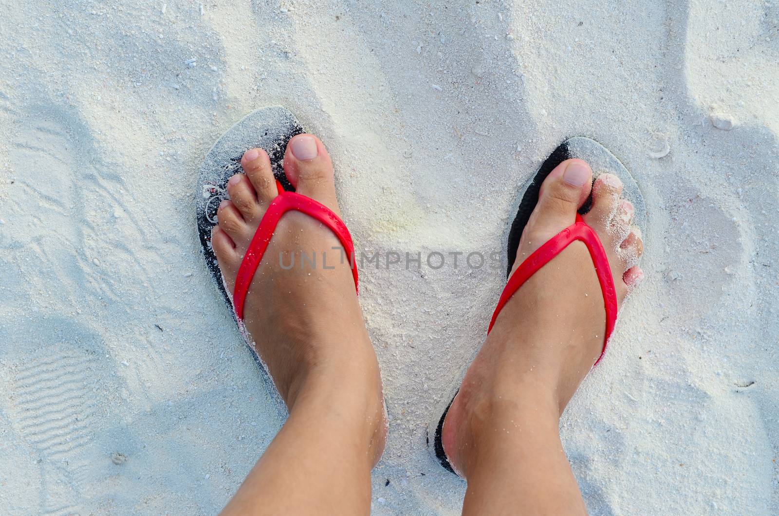 woman feet in the warm wet sand. Seaside holidays concept.