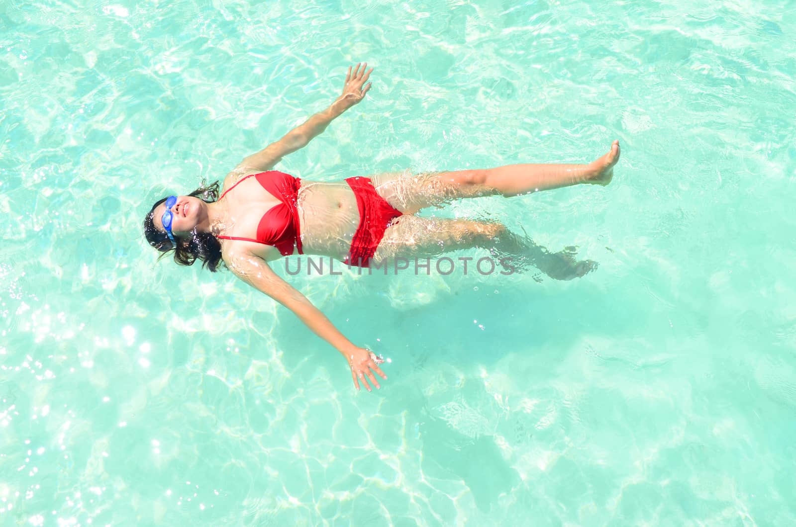 Woman swim and relax in the crystal-blue sea of tropical beach at  Maldives islands. Happy lifestyle concept.