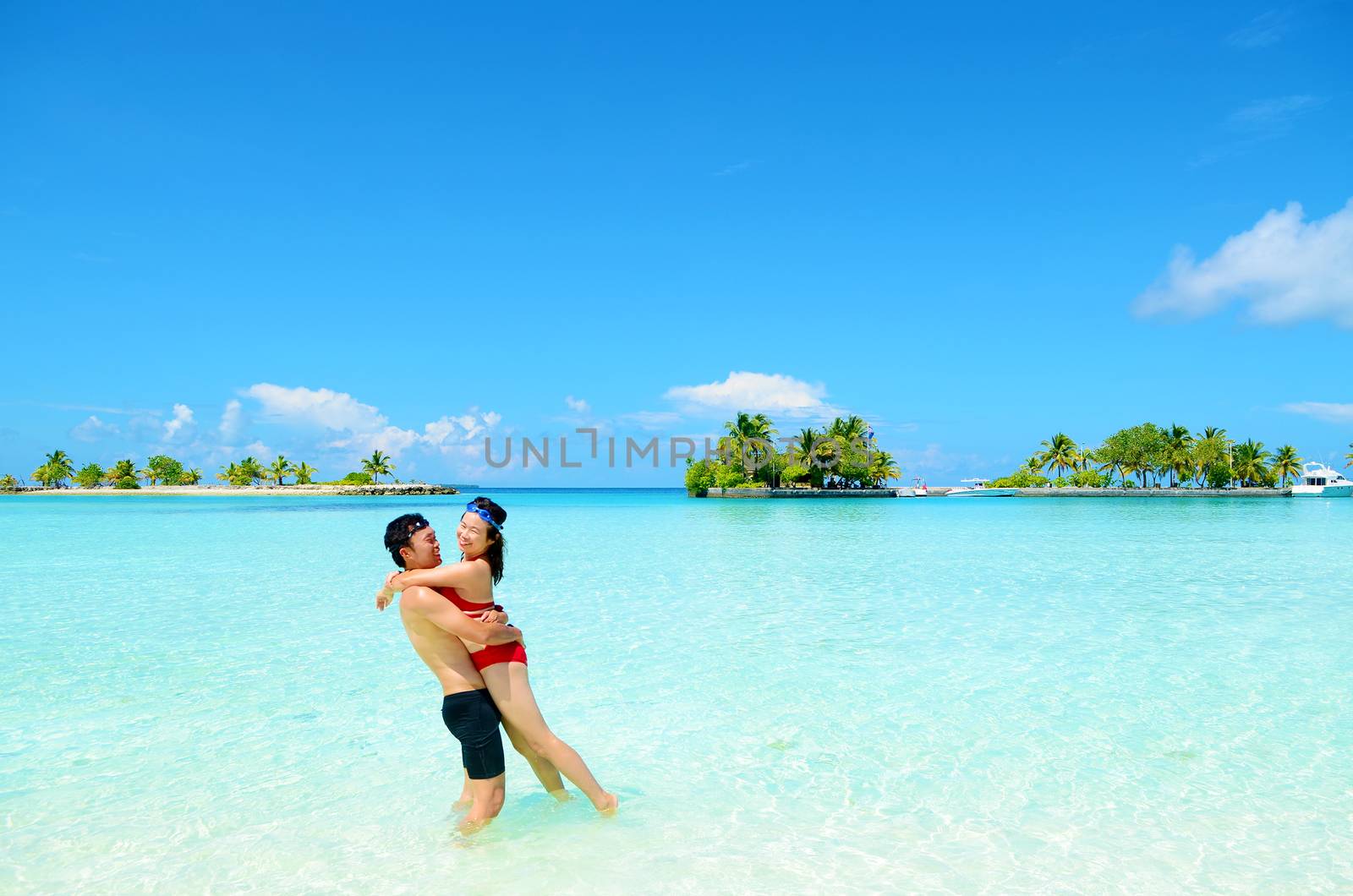Young happy asian couple  in clean water at summer vacation in Maldives island