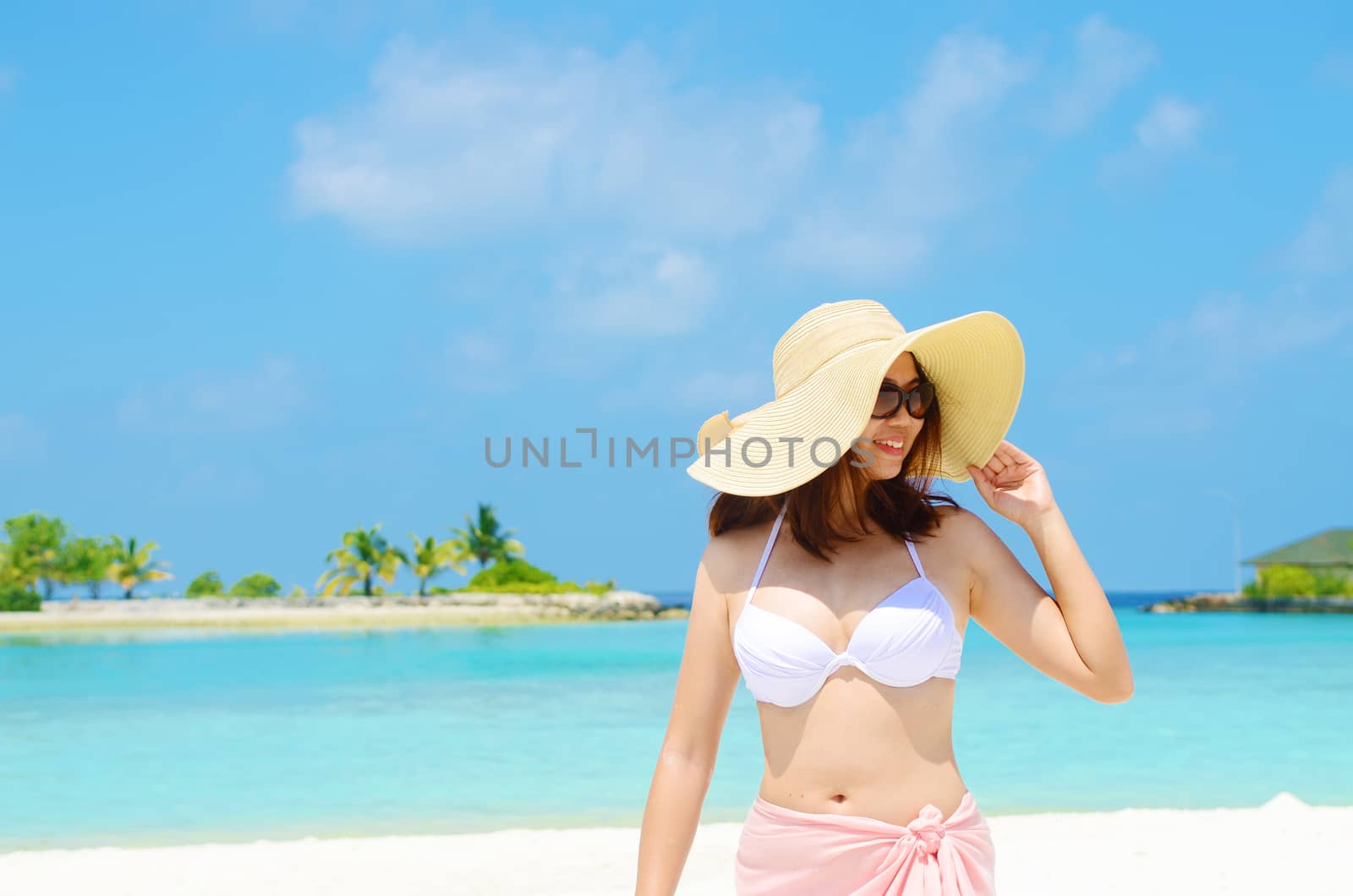Portrait of happy young woman in sunhat at  Maldives island. Travel and Vacation. 