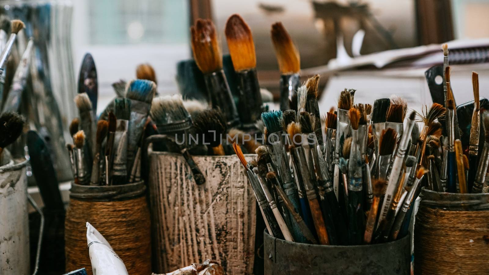 Table with brushes and tools in art workshop. Background. by natali_brill