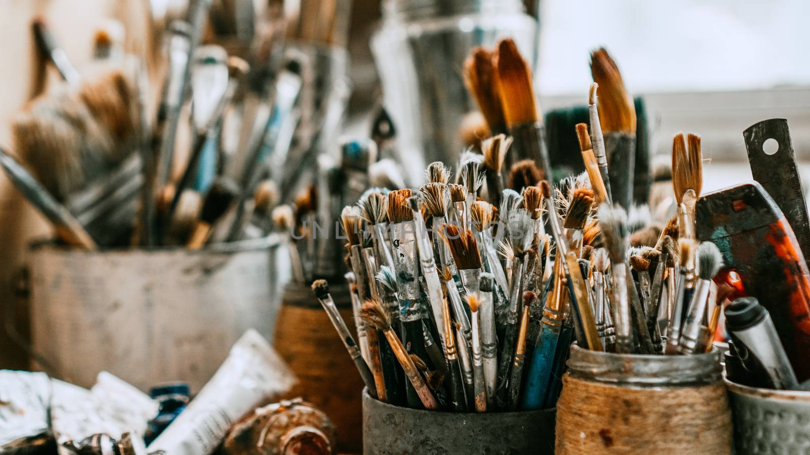 Table with brushes and tools in an art workshop. Background.