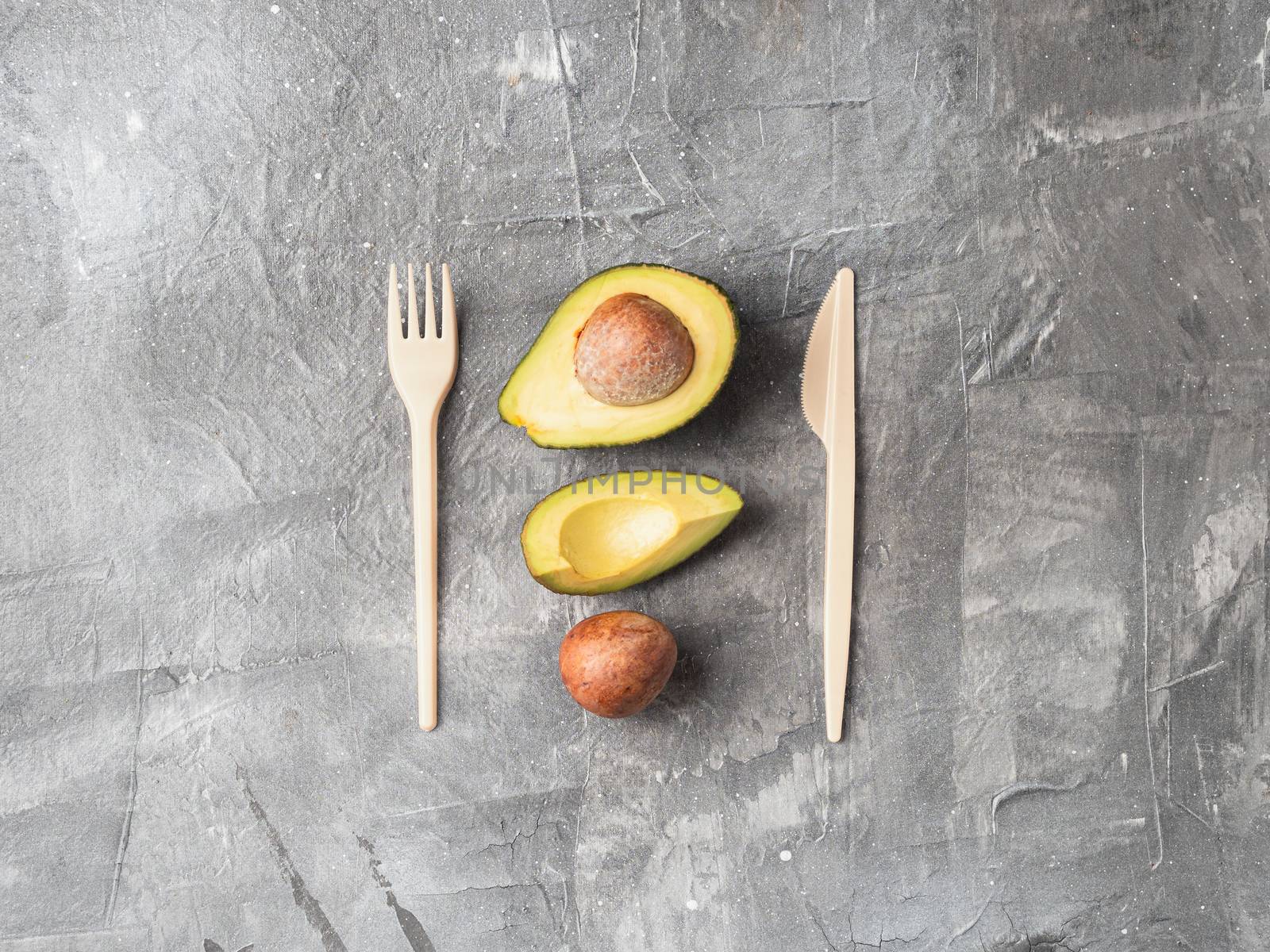 Avocado Seeds Biodegradable Single-Use Cutlery. Bioplastic - Great alternative to plastic disposable cutlery. Top view, flat lay. Copy space for text or design. Gray background