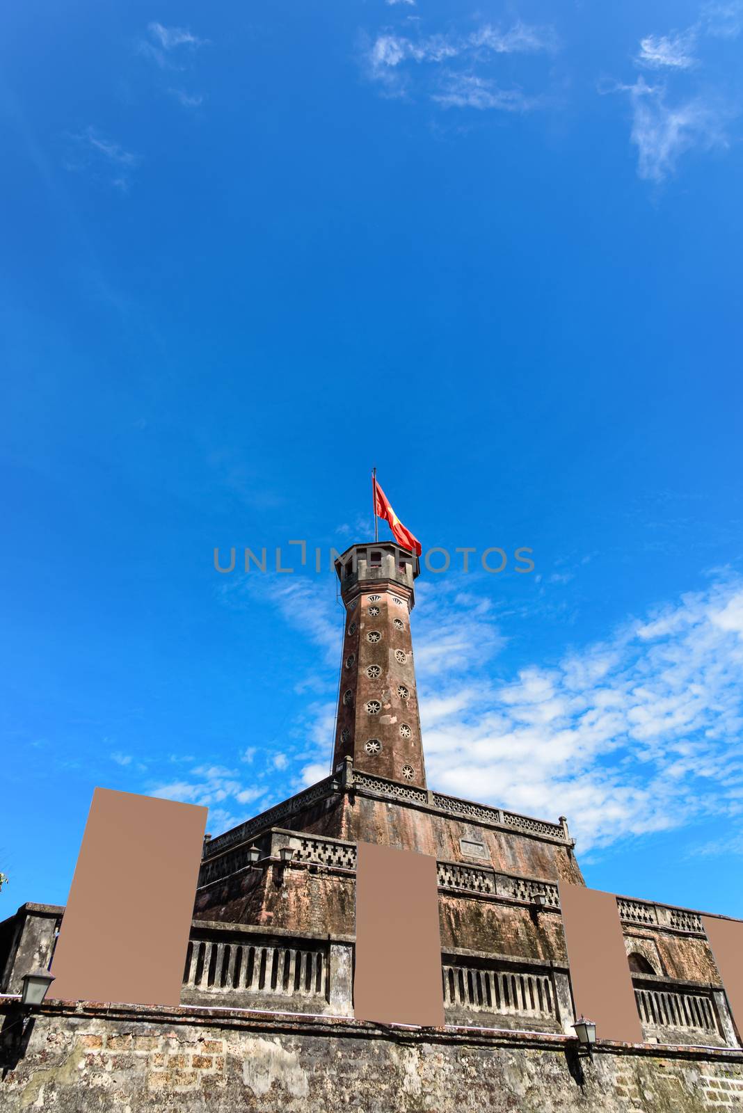 Hanoi flag tower with flying Vietnamese flag and empty standing billboard cloud blue sky by trongnguyen