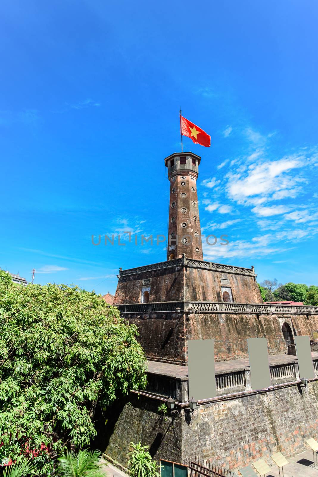 Hanoi flag tower with flying Vietnamese flag and empty standing billboard cloud blue sky by trongnguyen