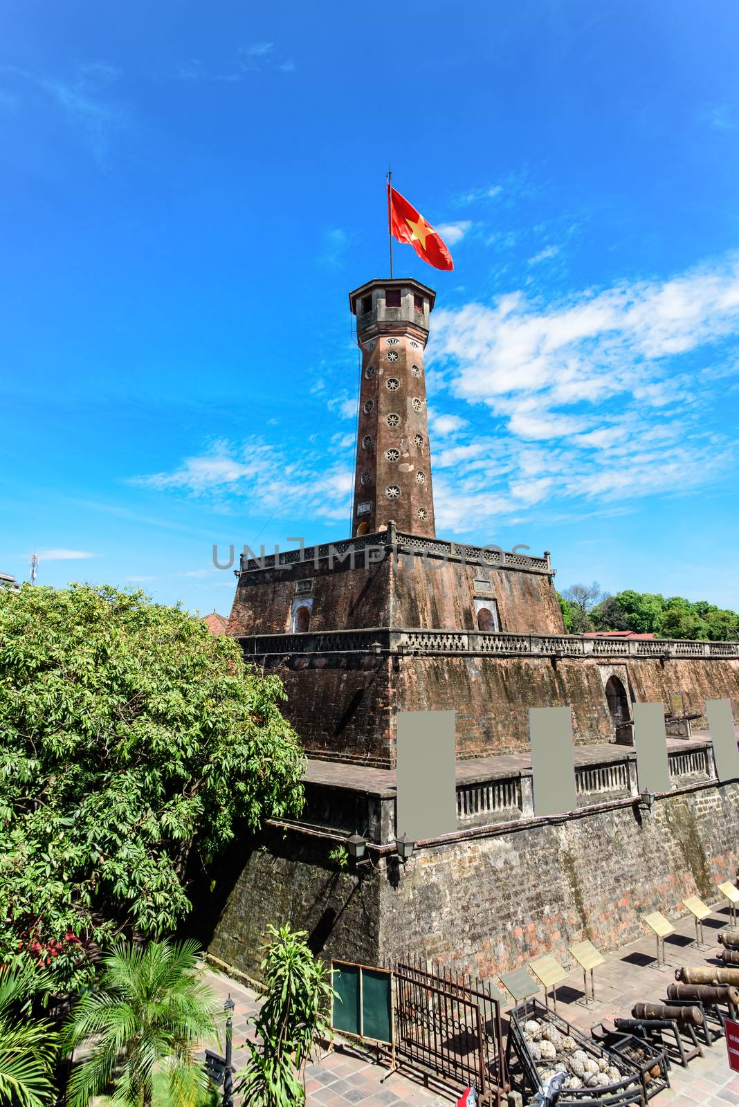 Hanoi flag tower with flying Vietnamese flag and empty standing billboard cloud blue sky by trongnguyen