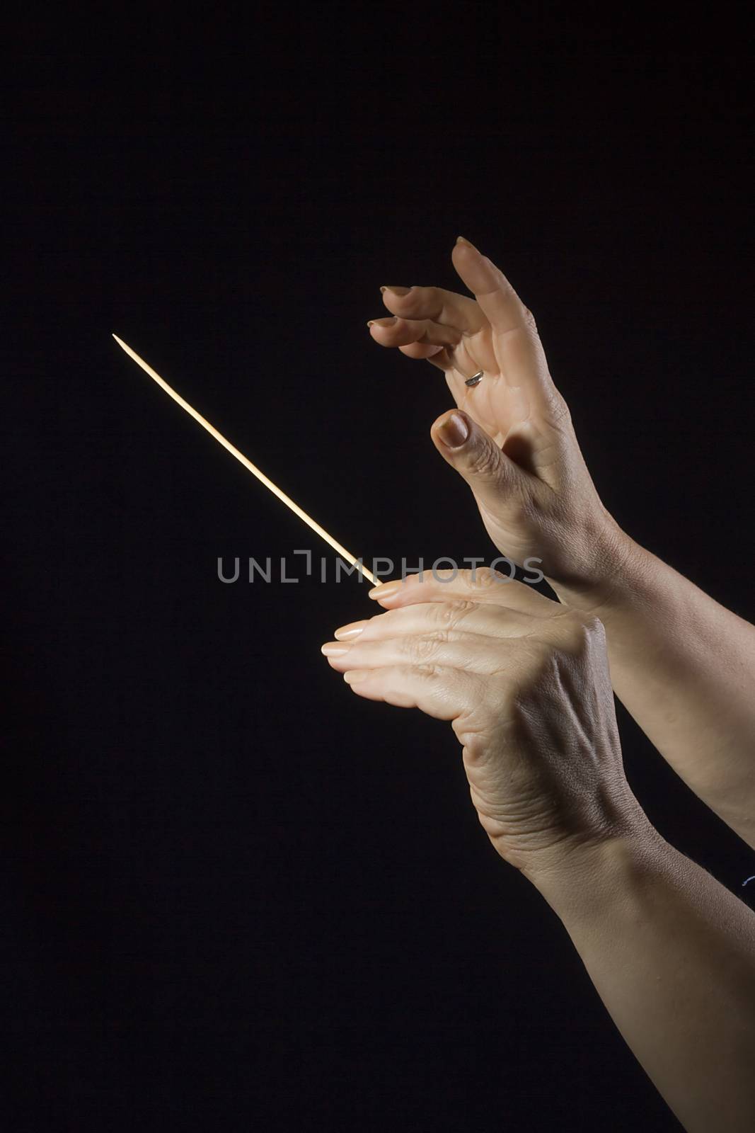 Female hands of an orchestra conductor on a black background