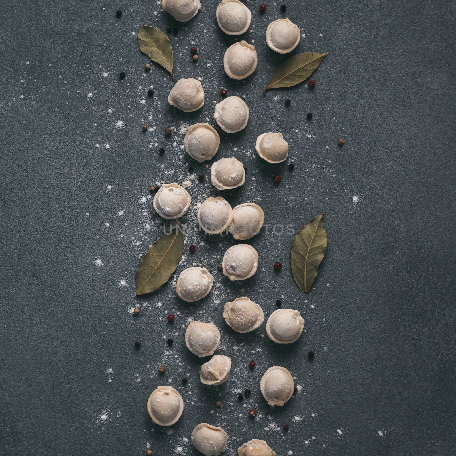 Beautiful scattered raw pelmeni on marble background by fascinadora