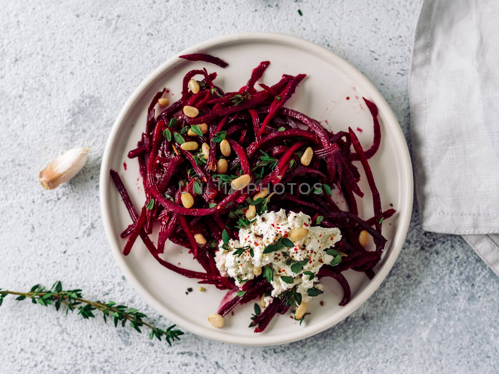 Raw beetroot spaghetti salad with soft cheese,nuts,thyme.Vegetable noodles - Fresh Beetroot Noodles with Ricotta and fresh thyme on plate. Copy space.Clean eating, raw vegetarian food concept.Top view
