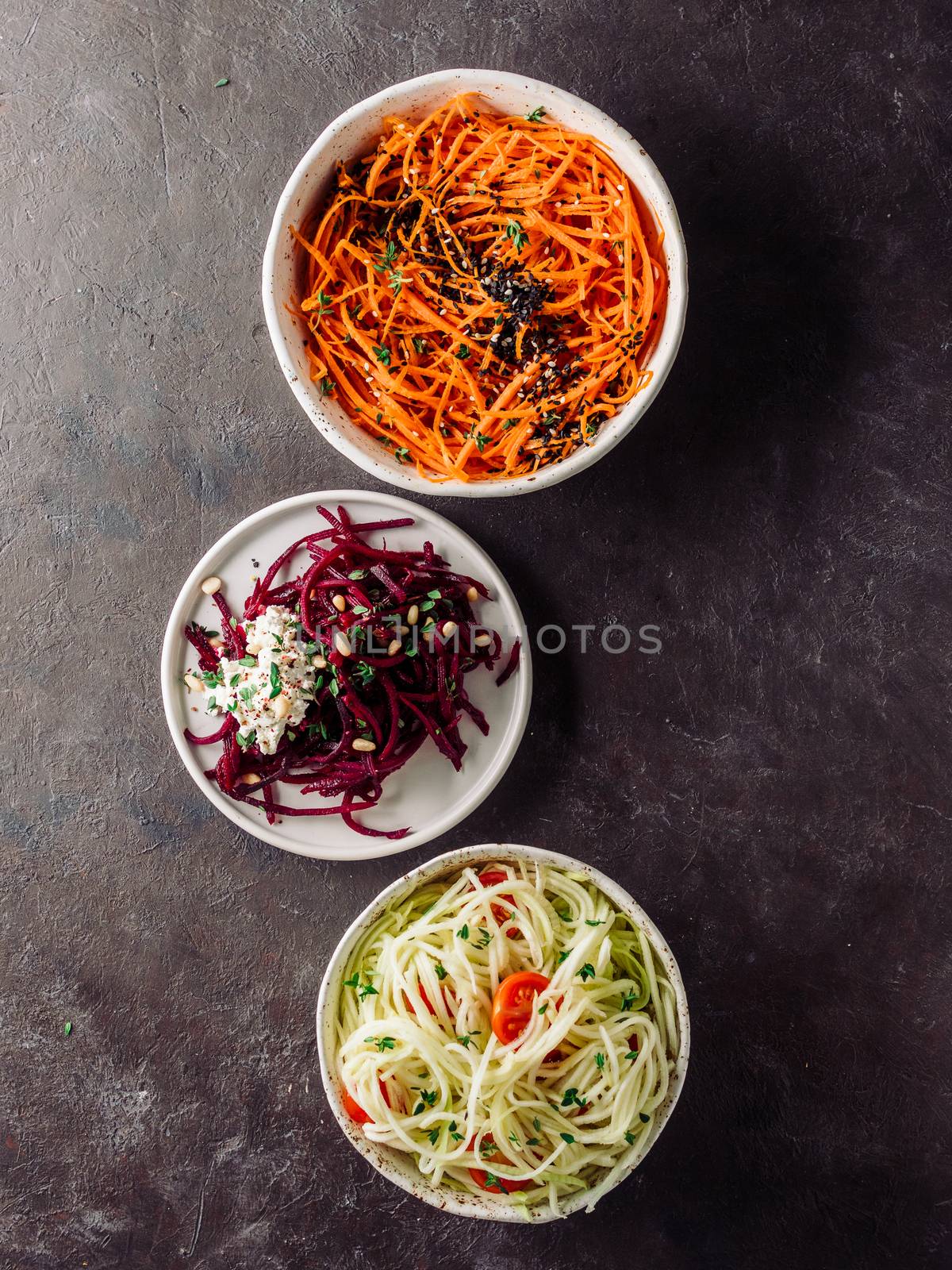 Ideas and recipes for healthy salad - spicy sesame carrot noodles salad,raw beetroot noodles wih ricotta,zucchini zoodles salad with tomatoes.Various vegetarian salads ready-to-eat.Top view.Copy space