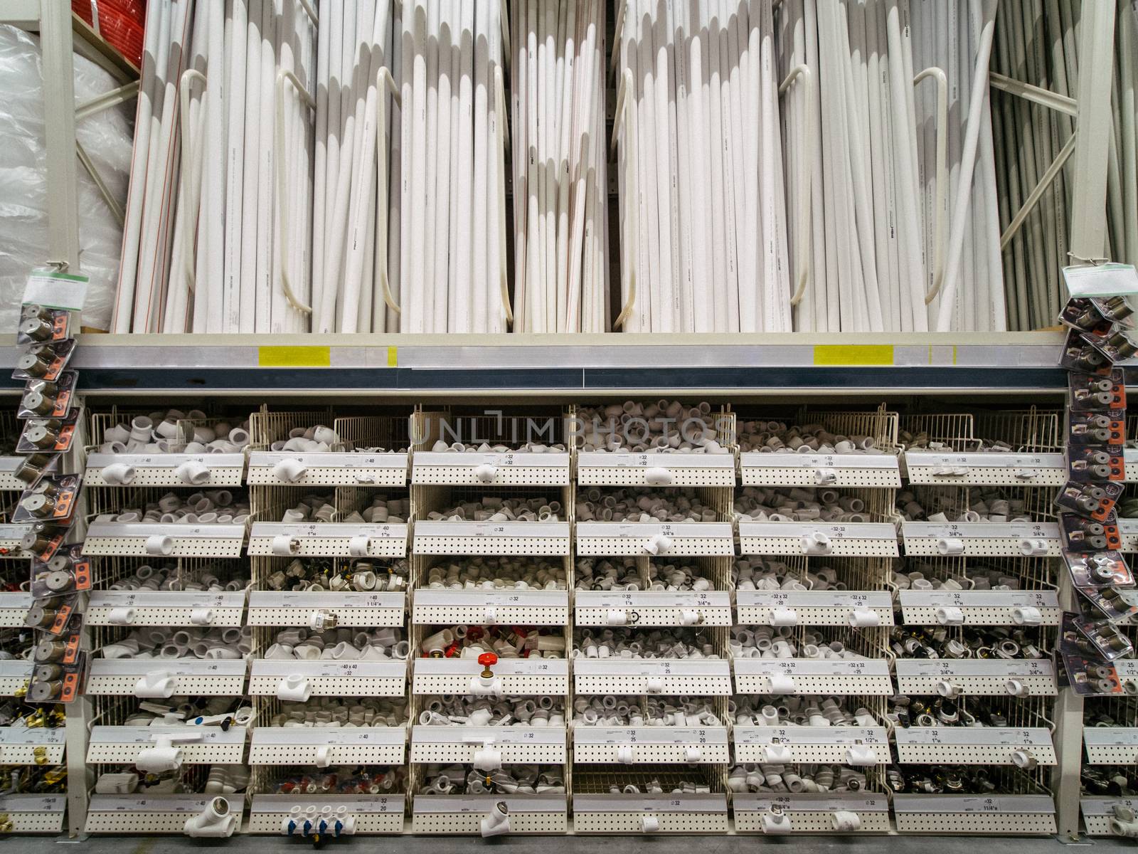 Store shelf with plastic pipes for aqueduck, plumbing. Warehouse of building materials in industiral store. Shallow DOF. Copy space