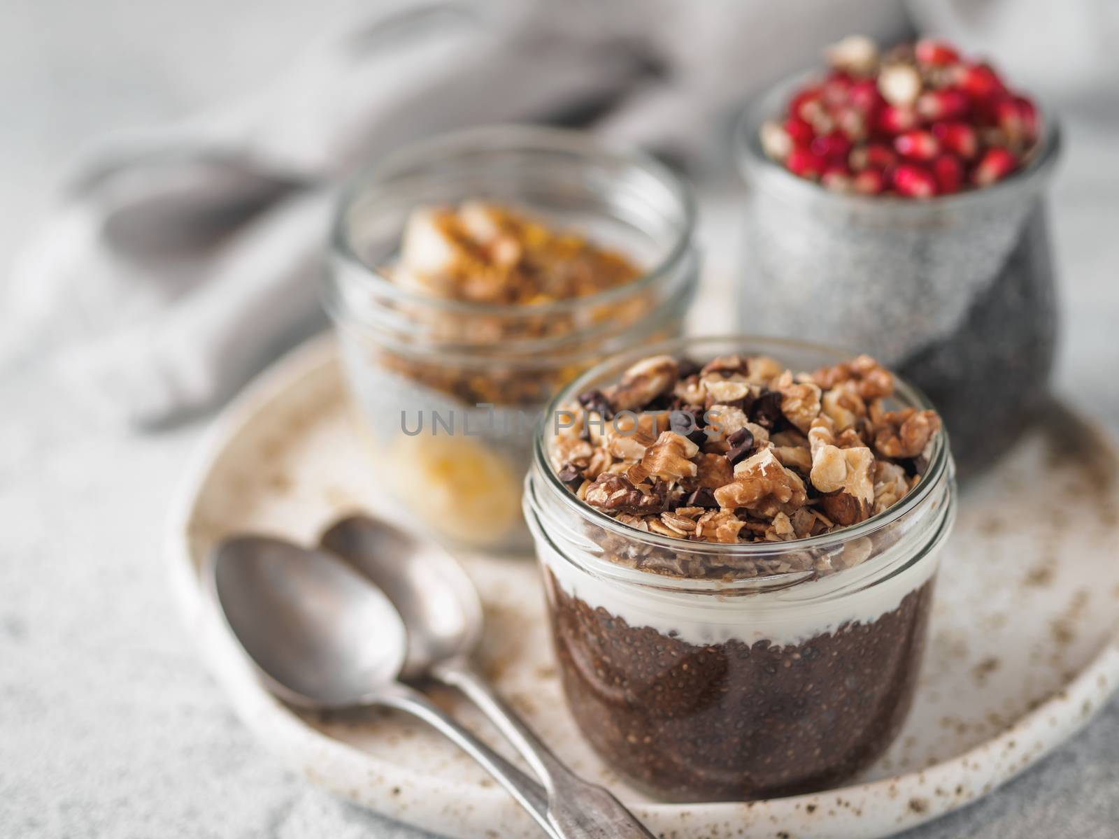 Set of chia pudding in different glass jars on table. Assortment of chia puding with different fruits, nuts,ingredients. Copy space for text. Superfood, detox,healthy overnight breakfast concept