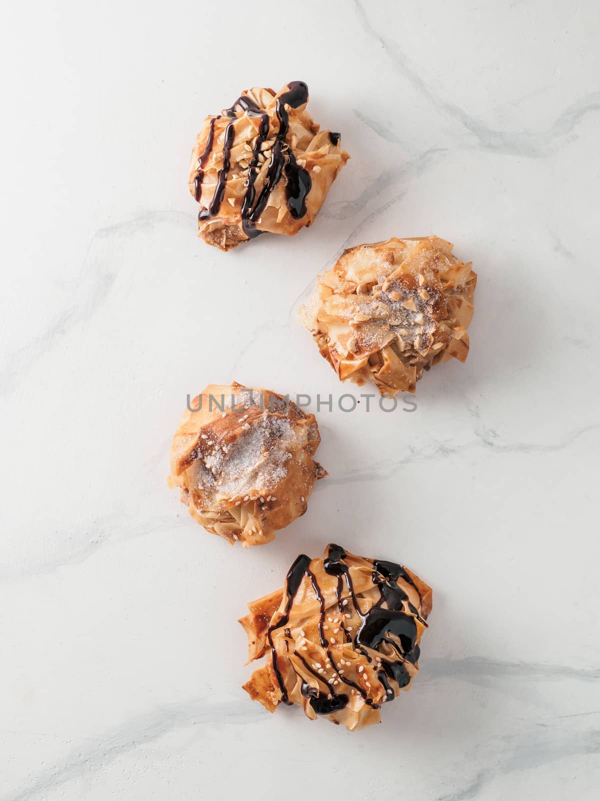 Ideas and recipes for sweet baking. Fillonuts - peanut butter and jelly fillo doughnuts on white marble table. Copy space for text. Vertical.