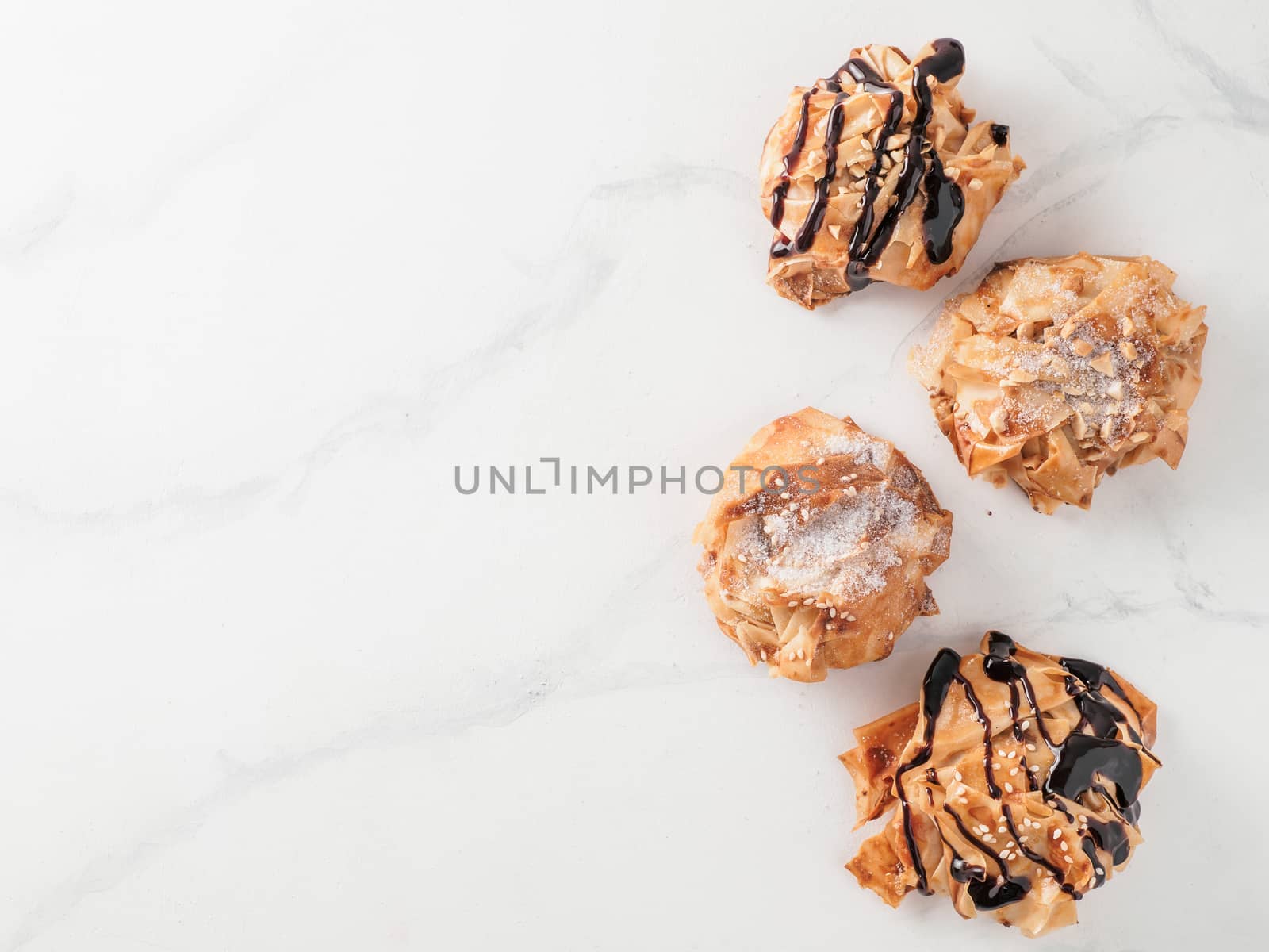 Ideas and recipes for sweet baking. Fillonuts - peanut butter and jelly fillo doughnuts on white marble table. Copy space for text