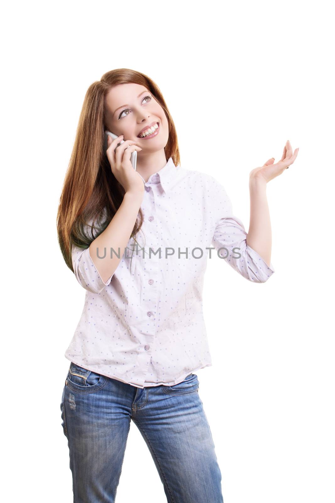 Smiling beautiful young woman in casual clothing talking on a phone and gesturing with one hand, isolated on white background.