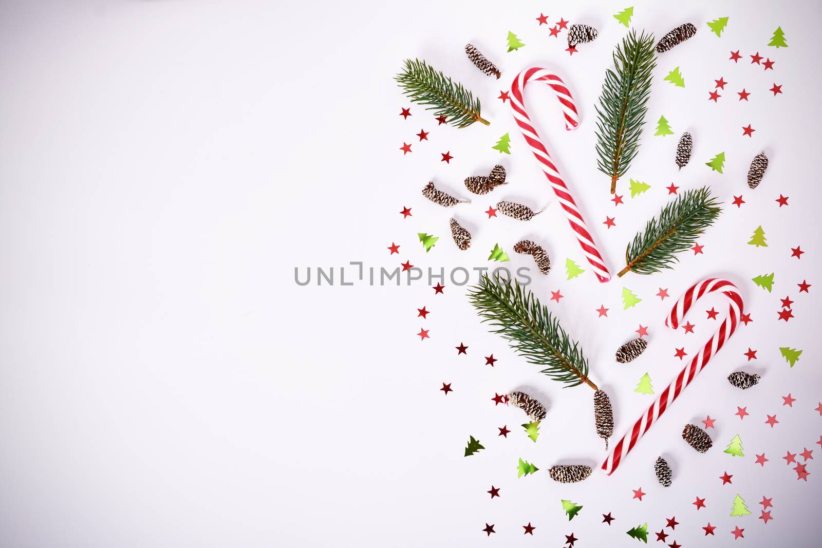 Seasonal composition with fir branches, candy cane and confetti by Mendelex