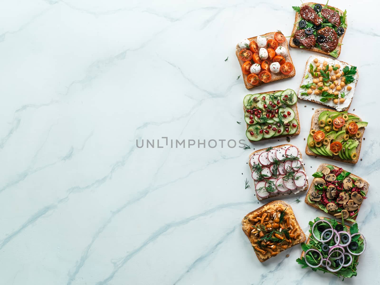 Assortment vegan sandwiches on white marble background. Set different vegetarian smorrebrod. Top view or flat lay. Copy space for text.