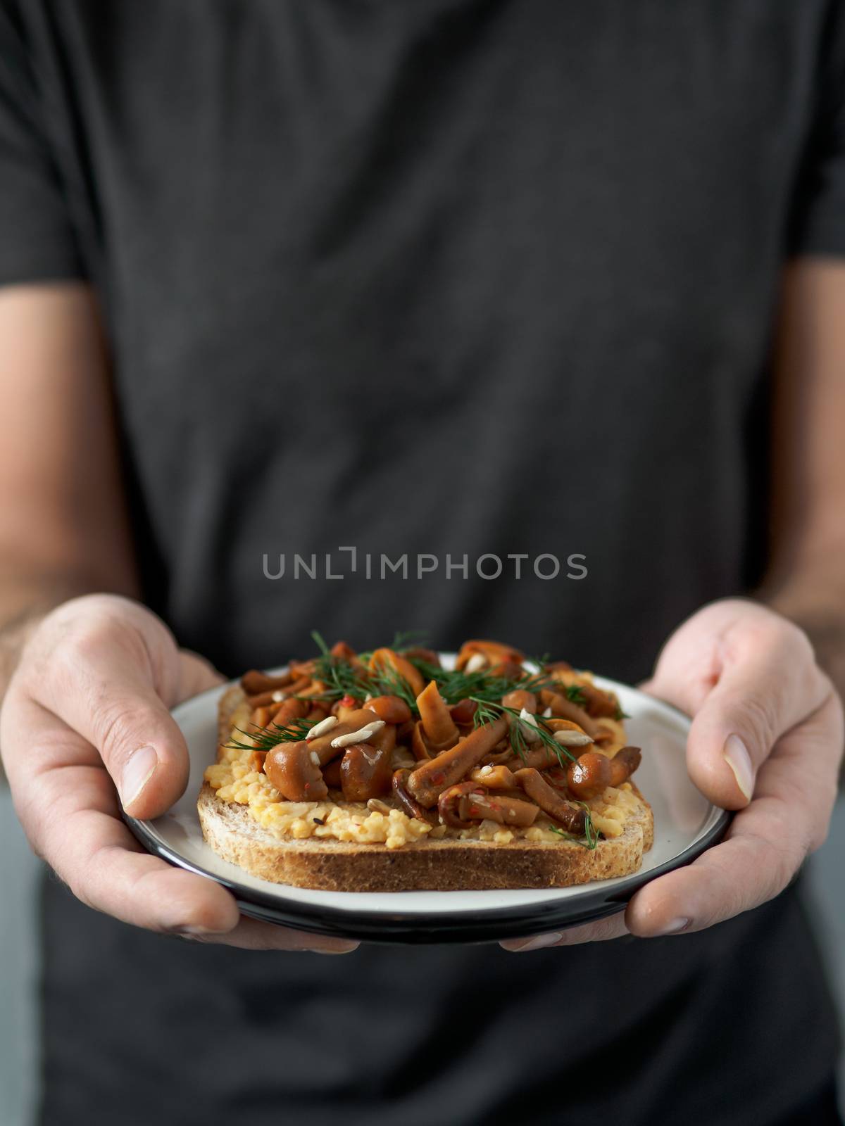 Vegan sandwich with mushrooms in male hands by fascinadora