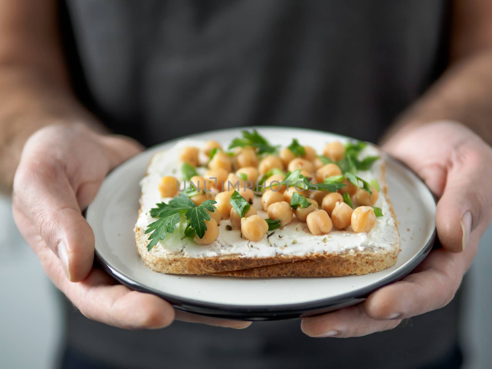 Vegan sandwich with chickpea in male hands by fascinadora
