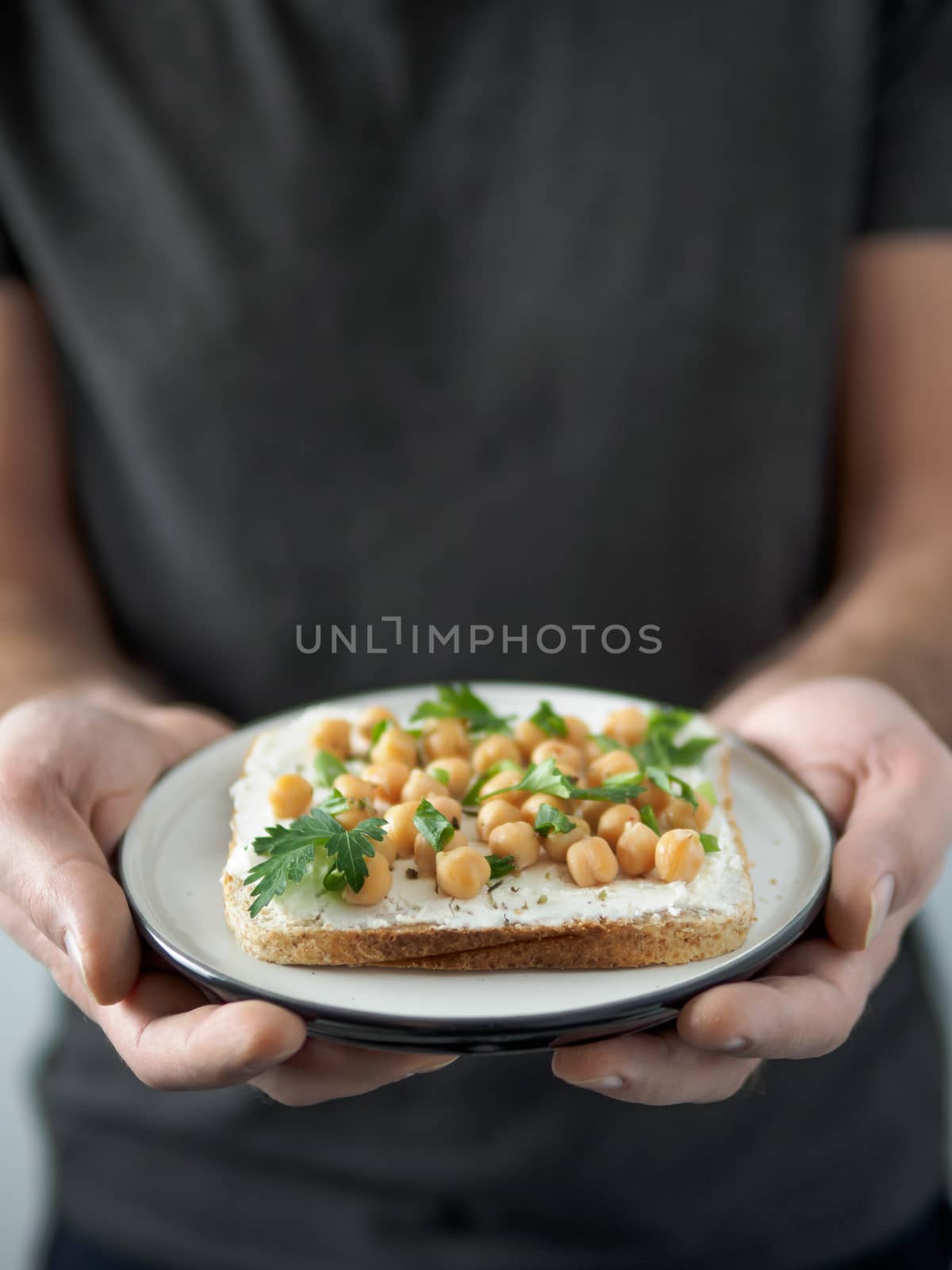 Vegan sandwich with chickpea in male hands by fascinadora