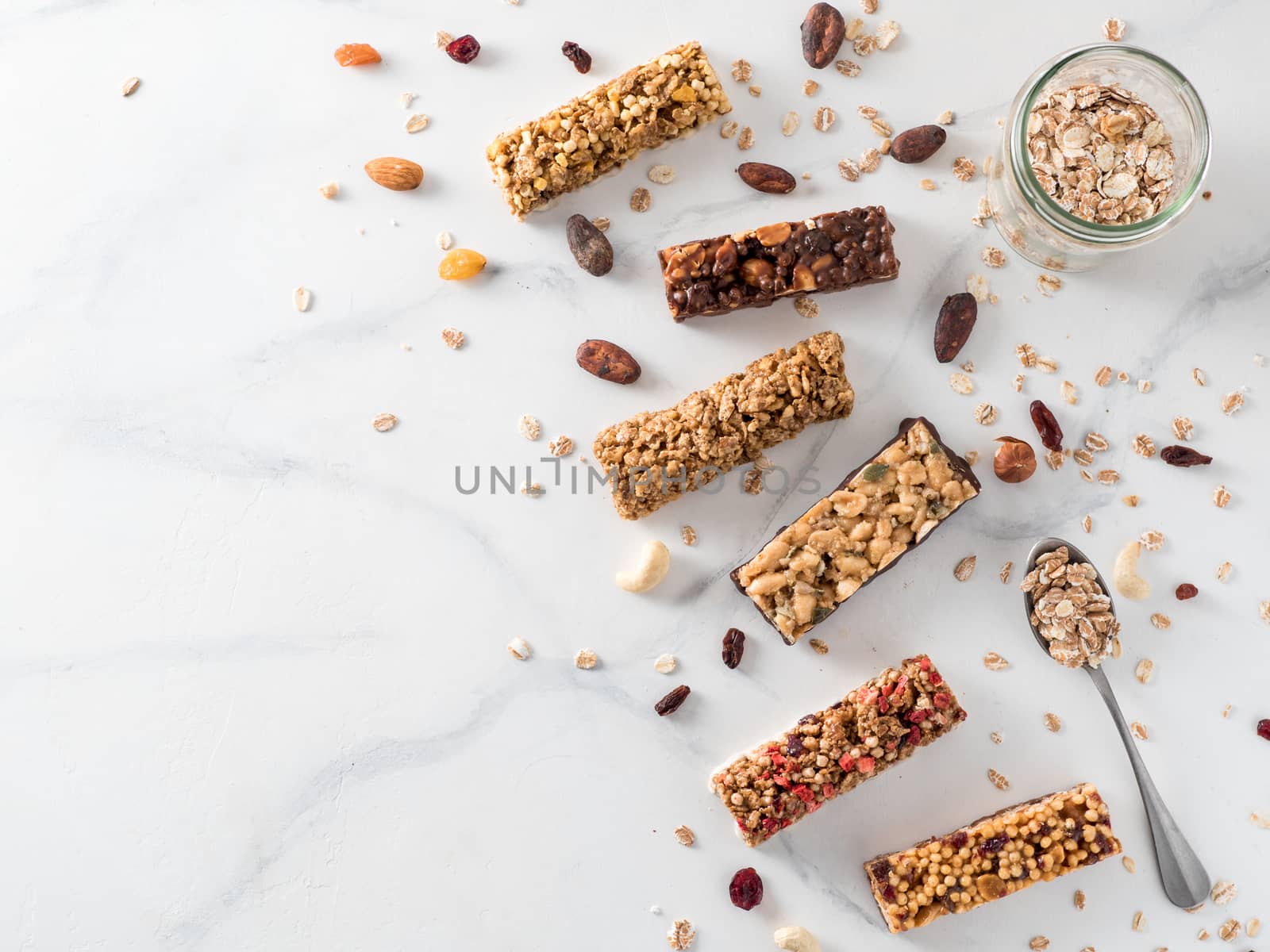 Granola bar with copy space. Set of different granola bars on white marble table. Shallow DOF. Top view or flat lay.