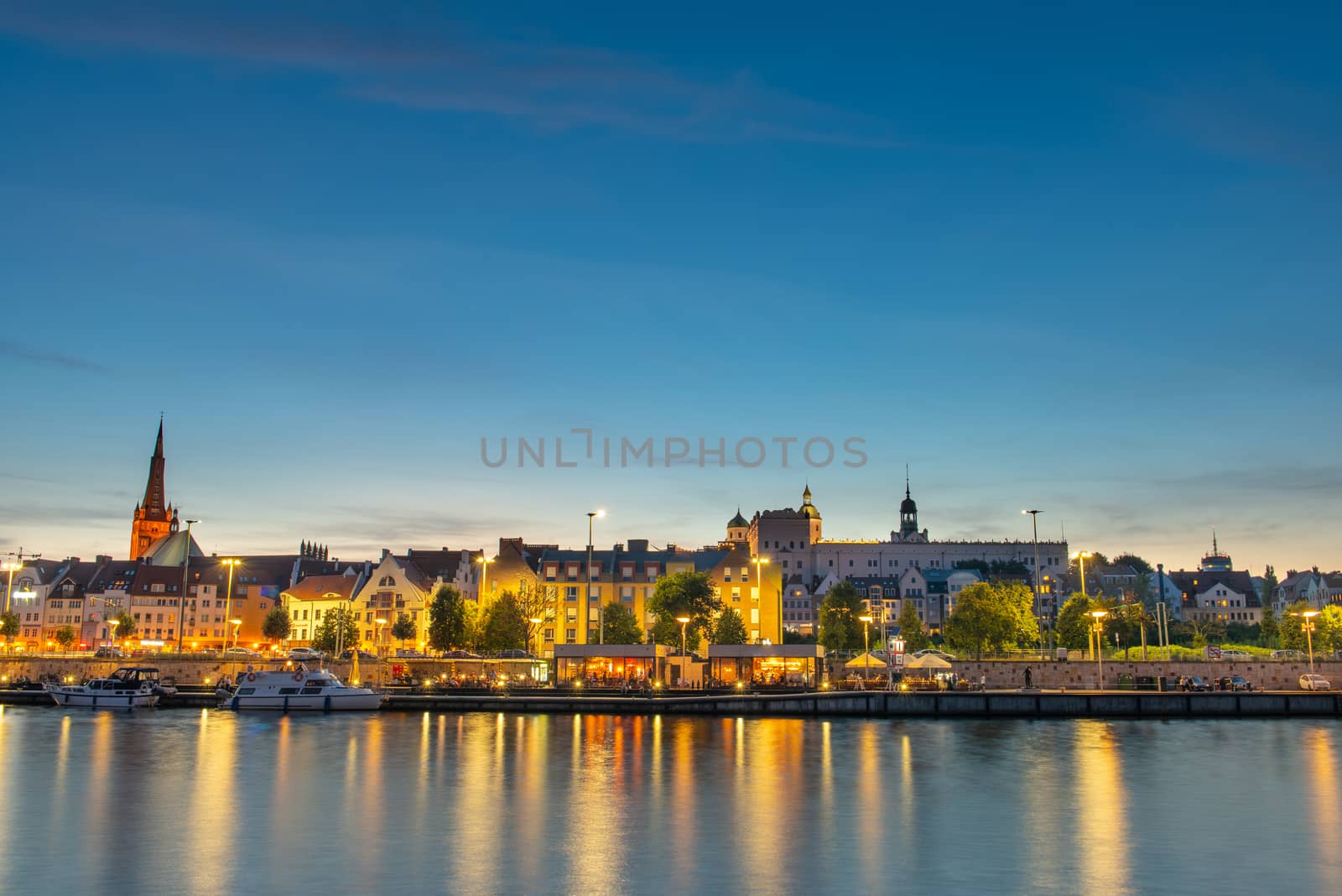 Szczecin. Night view from across the river to the illuminated historic center. Odra river. Chrobry embankments in Szczecin