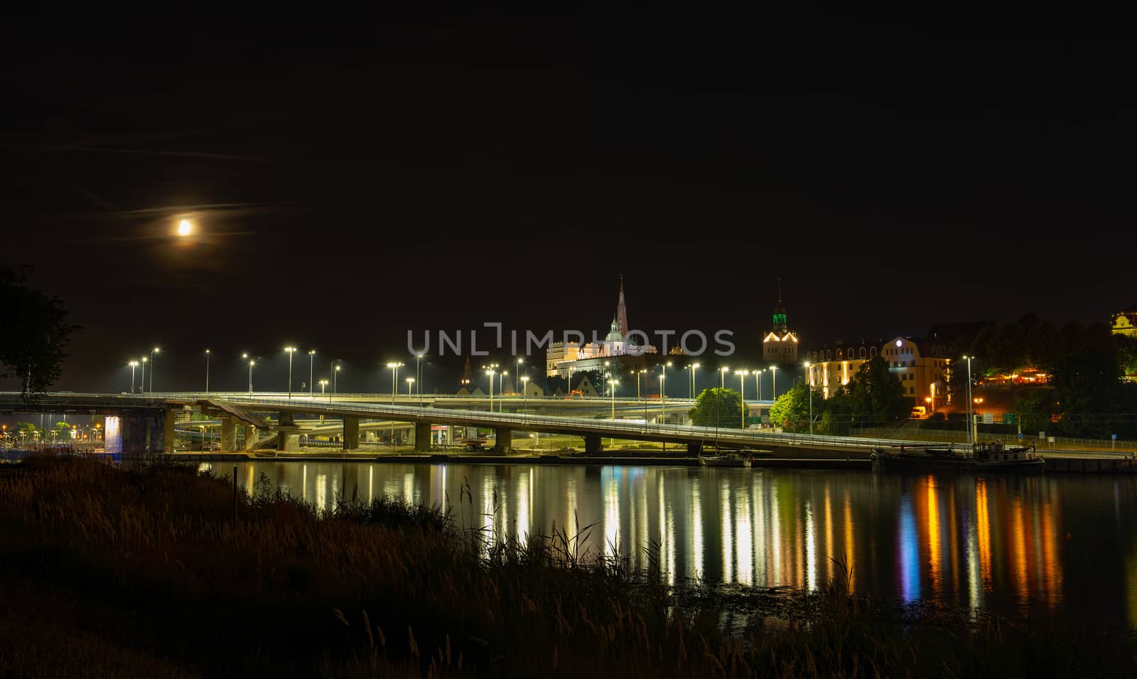 Szczecin. Night view from across the river to the illuminated historic center. Odra river. Chrobry embankments in Szczecin