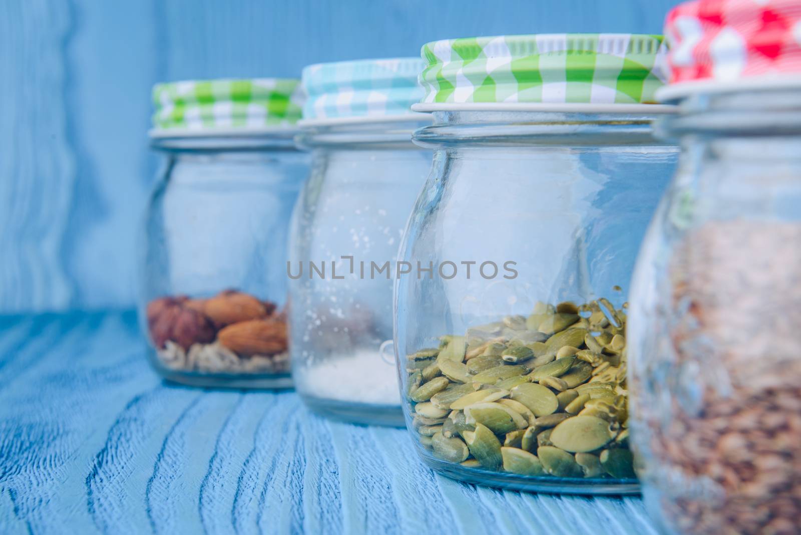 Almonds in a jar on the blue wooden table.