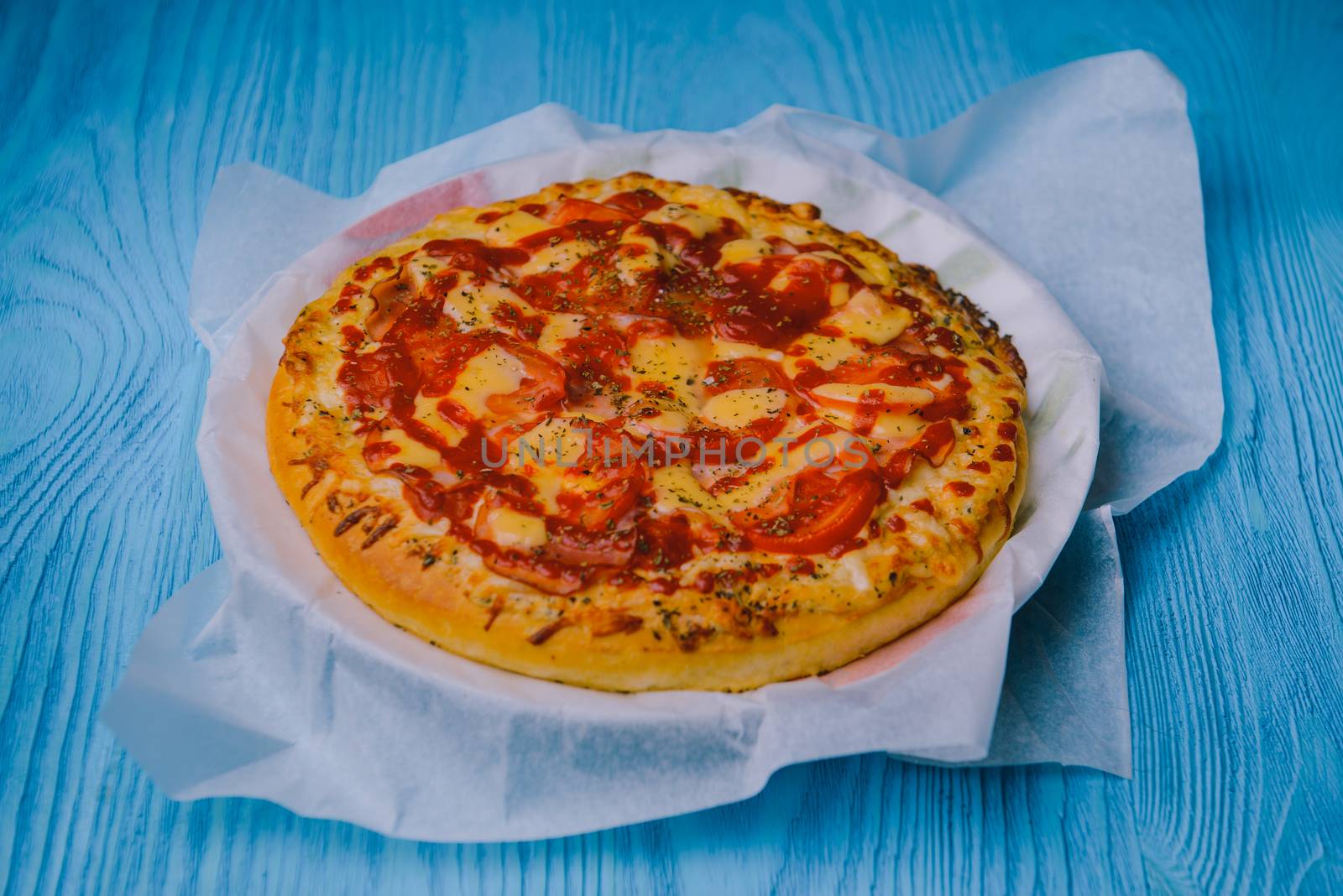 Homemade pepperoni pizza on the table. Tomato, cheese and ham main ingredients.