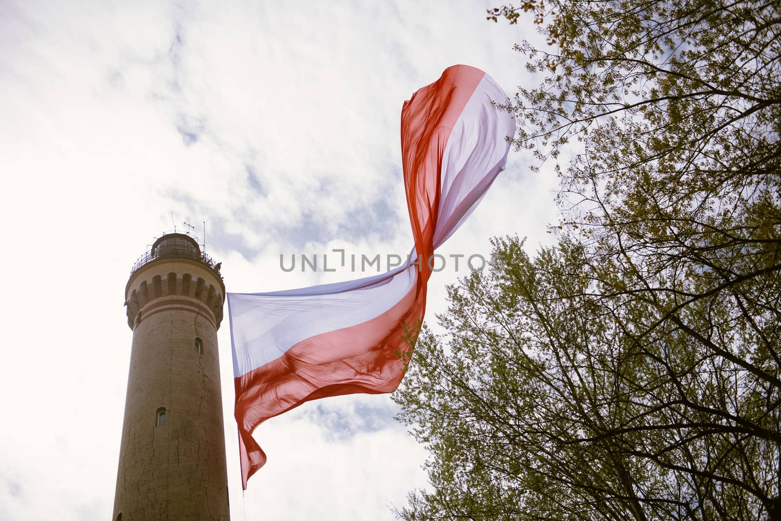 Polish flag hung on at historical lighthouse located in Swinoujscie, Poland, The construction was build in 1828 and height is 65 meters. 19th century. Top tallest Lighthouse in the World
