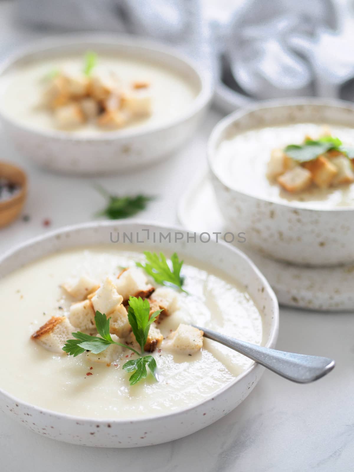 cauliflower potato soup puree on white marble tabletop, Creamy cauliflower soup with toasted bread croutons. Vegetarian healthy food concept. Ideas and recipes for winter meal. Vertical.