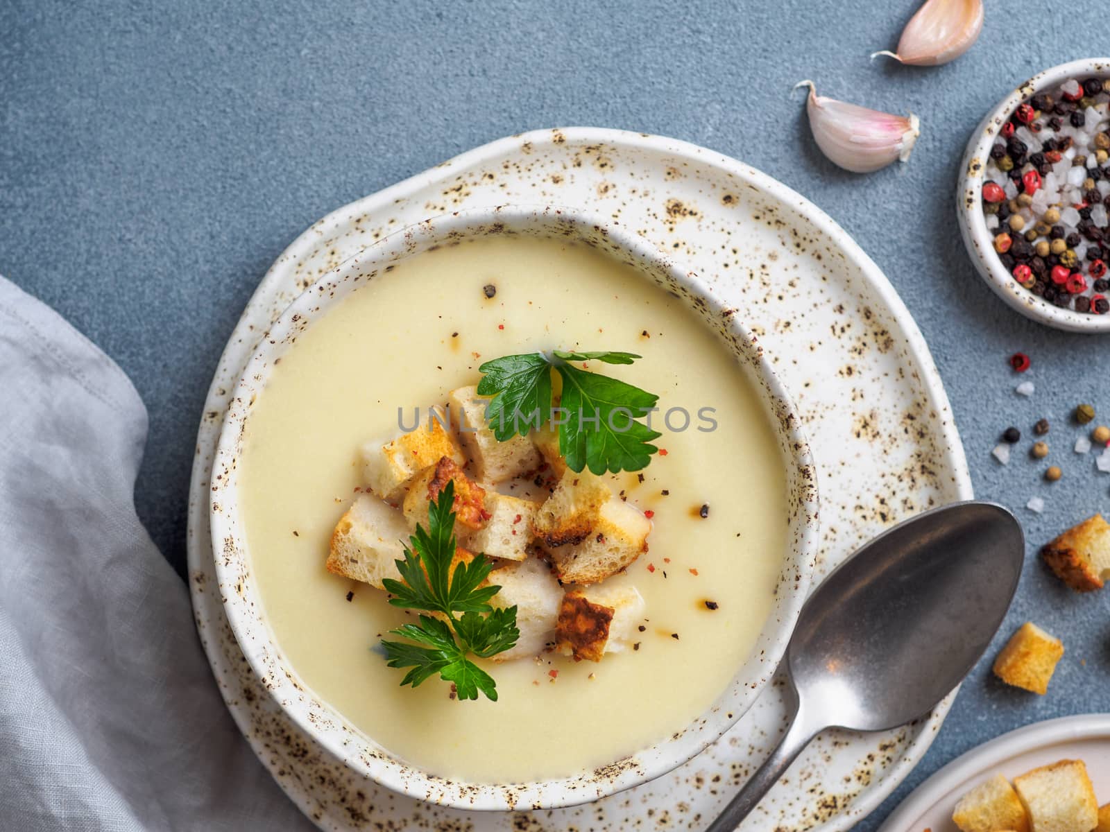 cauliflower potato soup puree on stone background, Creamy cauliflower soup with toasted bread croutons. Vegetarian healthy food concept. Ideas and recipes for winter meal. Top view flat lay.Copy space