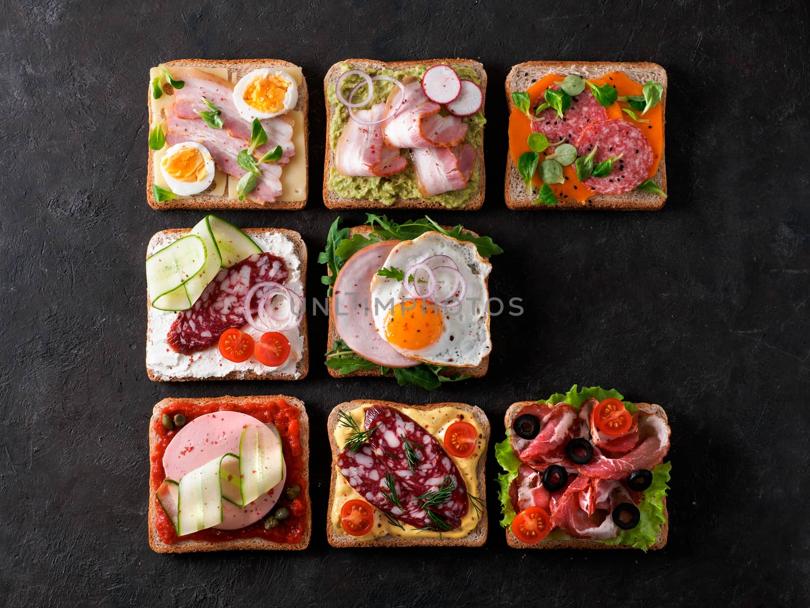 Set of eight different sandwiches with meat in square shape, copy space for text. Top view or flat lay. Assortment meat toasts on black background. Idea, creative concept for sausage maker