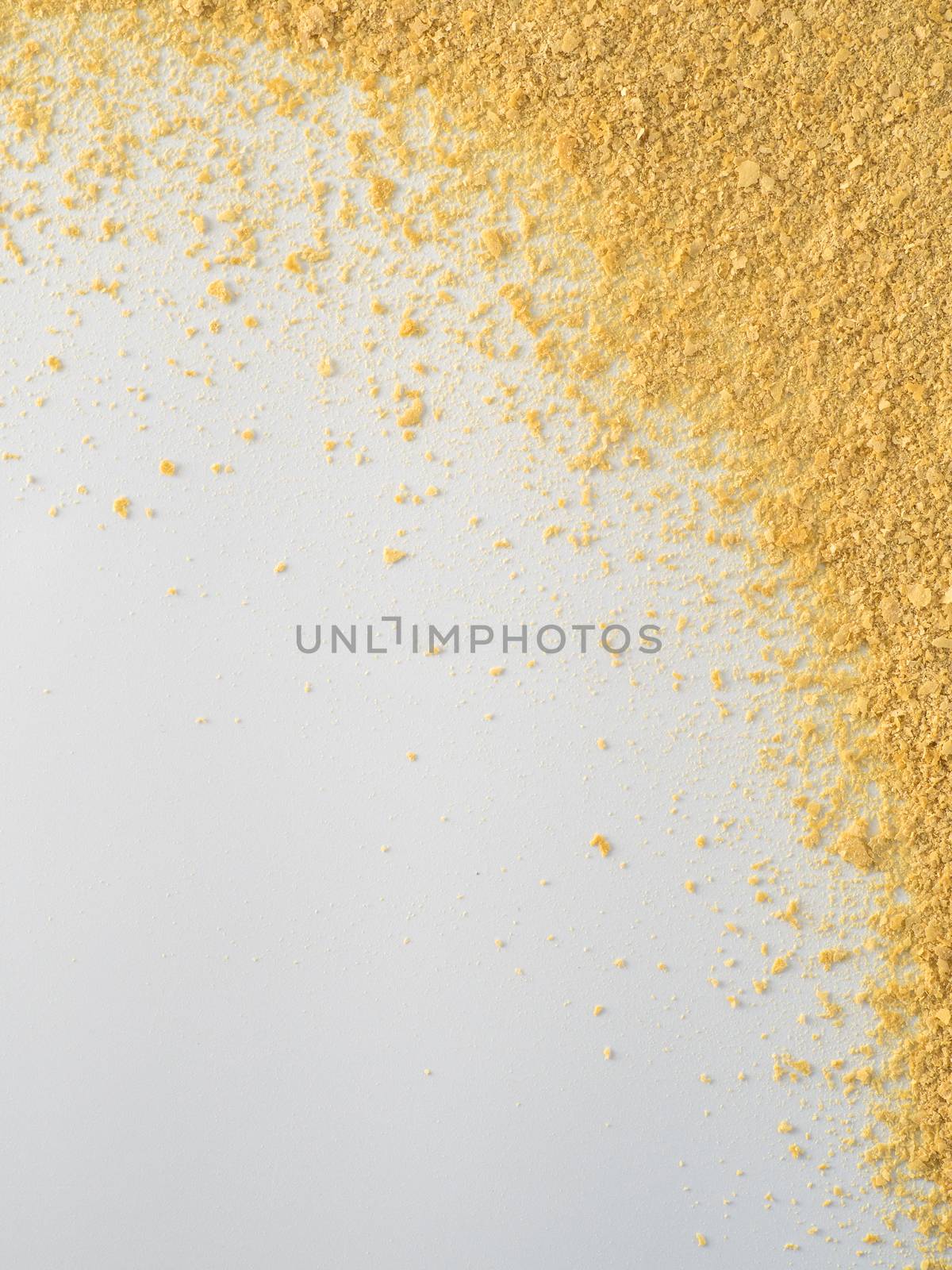 Nutritional yeast on white background. Nutritional inactive yeast top view. Copy space. Nutritional yeast is vegetarian superfood with cheese flavor, for healthy diet. Vertical.