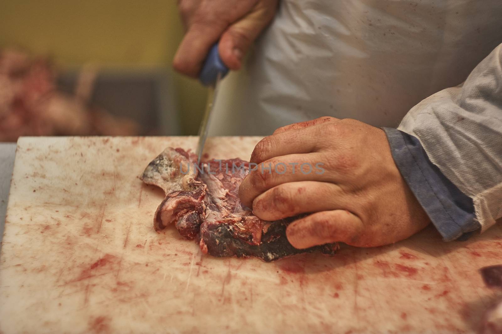 butcher who slices a steak in his butcher to prepare it for sale
