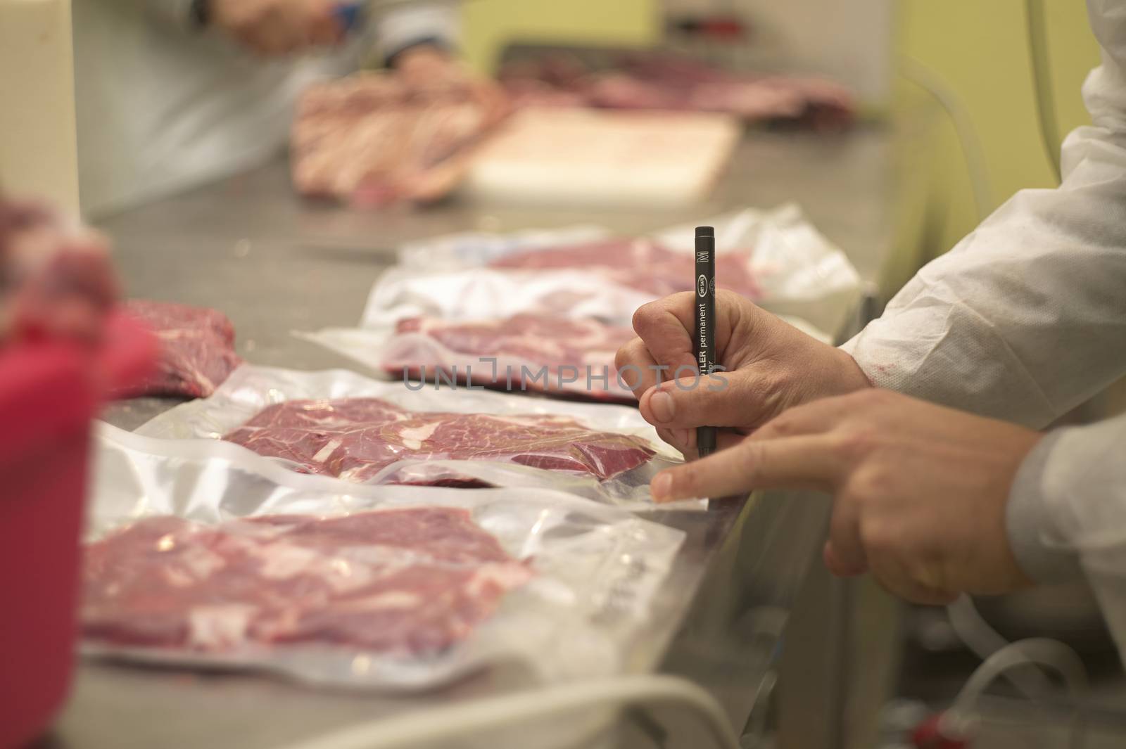 reparto di una macelleria in cui vengono tagliati i pezzi di carne per poi essere messi dentro a buster di plastica per essere conservata sottovuoto.