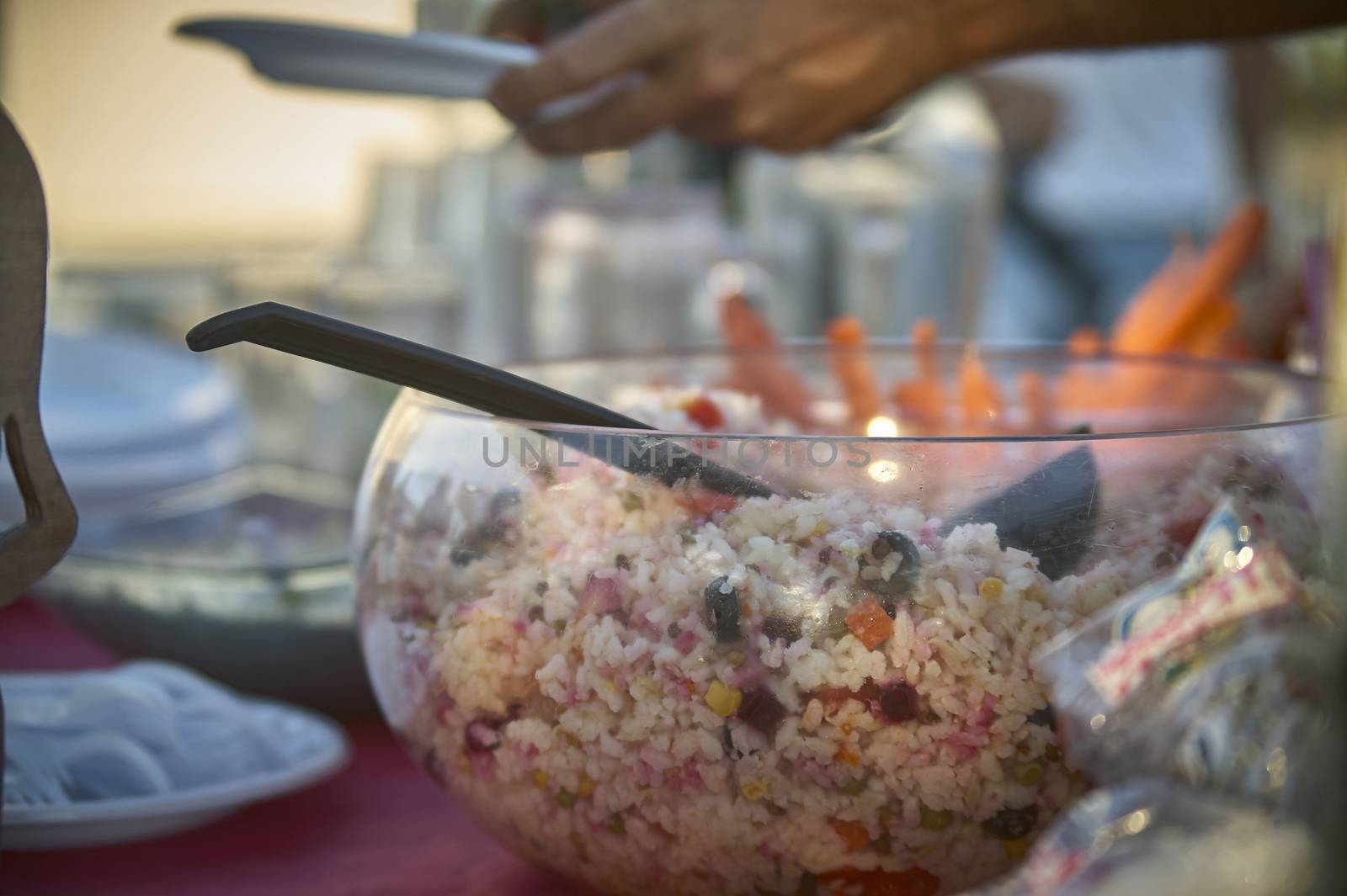Bowl full of rice salad resting on the table during an aperitif to satisfy the hunger of the banqueting. Typical dish of Italian cuisine.
