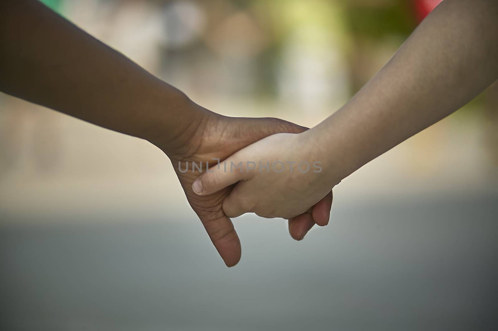 Hands of children shaking, one of the caucasian or white complexion, the other black. Symbol of inertness and equality between the races.