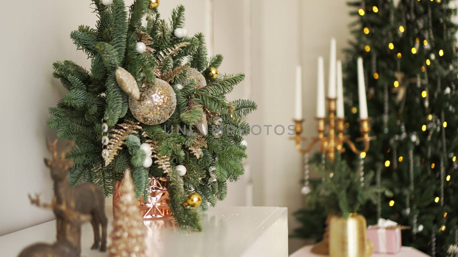 Christmas morning. Classic apartments with white interior, decorated tree, candles, christmas decor in gold color