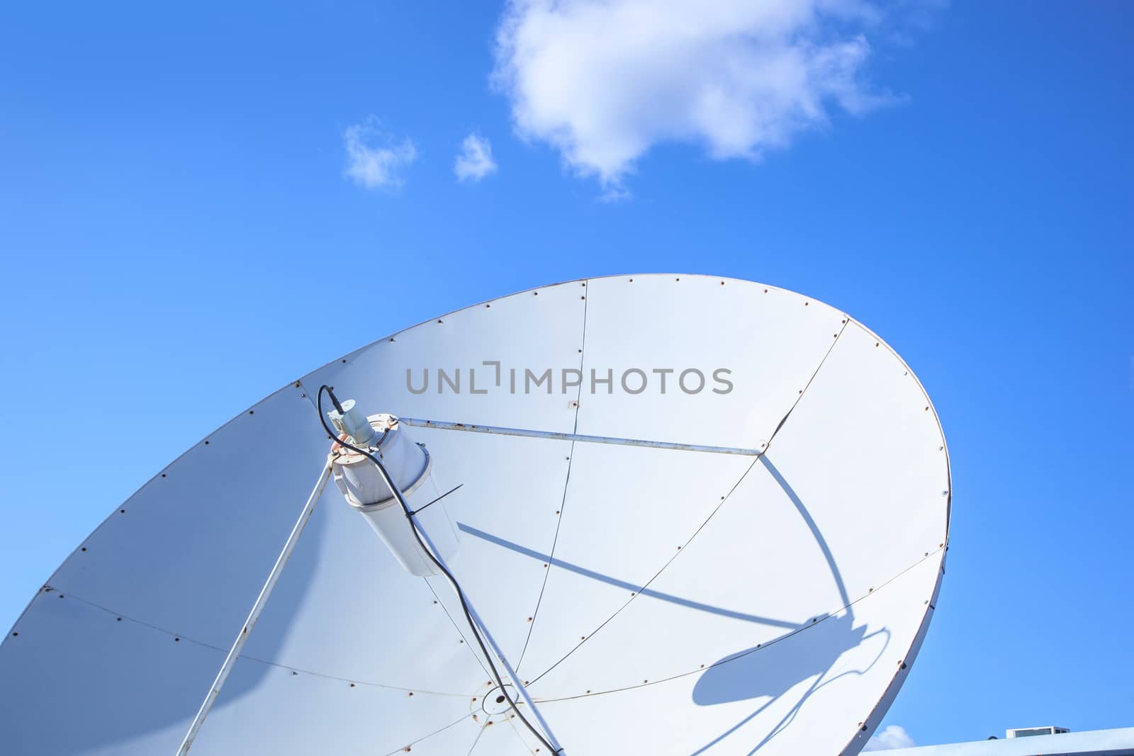 White big parabolic satellite antenna for telecommunications on a background of blue sky. by SlayCer