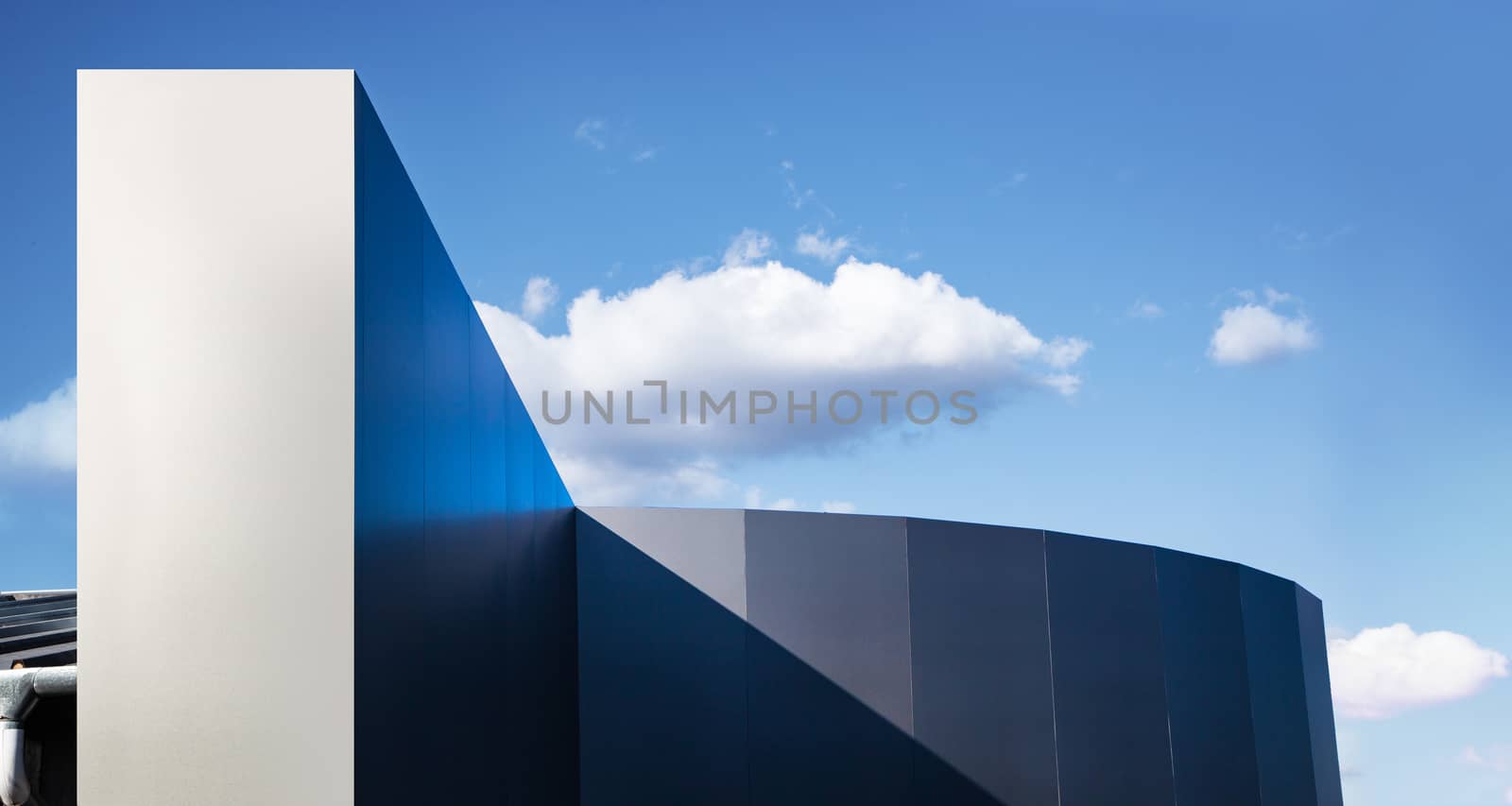Modern fragment on a construction building, against blue sky, Sunny day