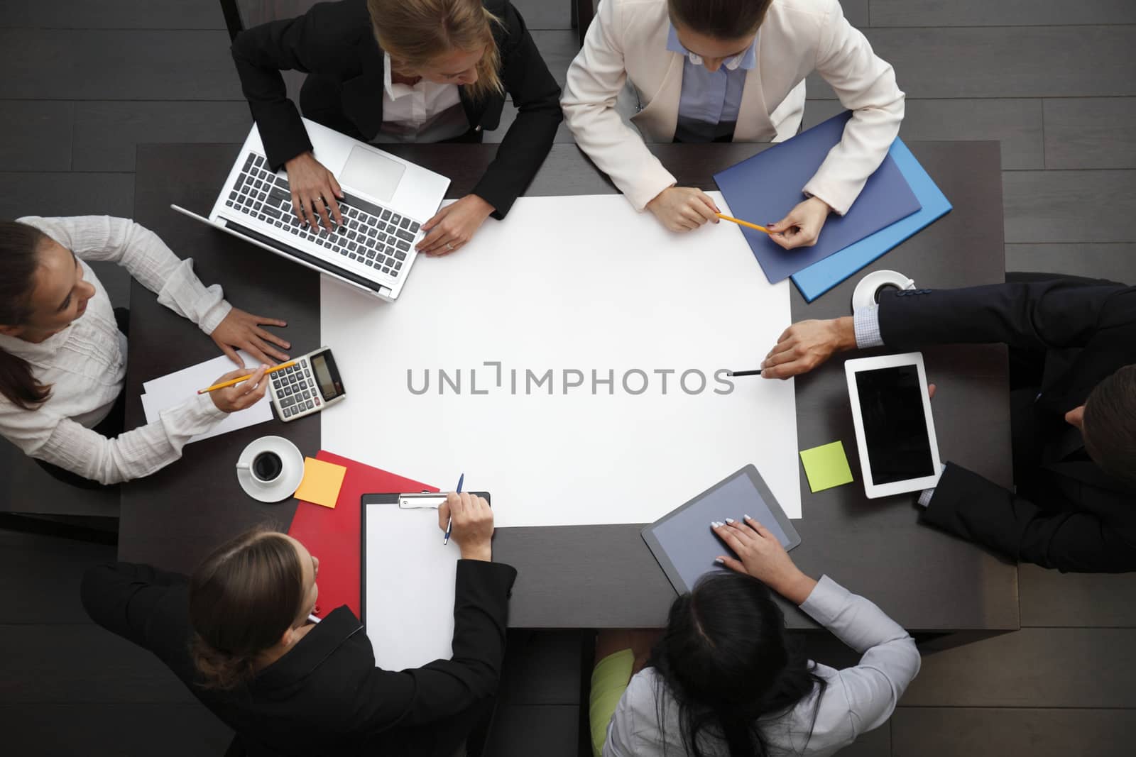 Business workplace with people, cup of coffee, digital tablet, smartphone, papers and various office objects on table