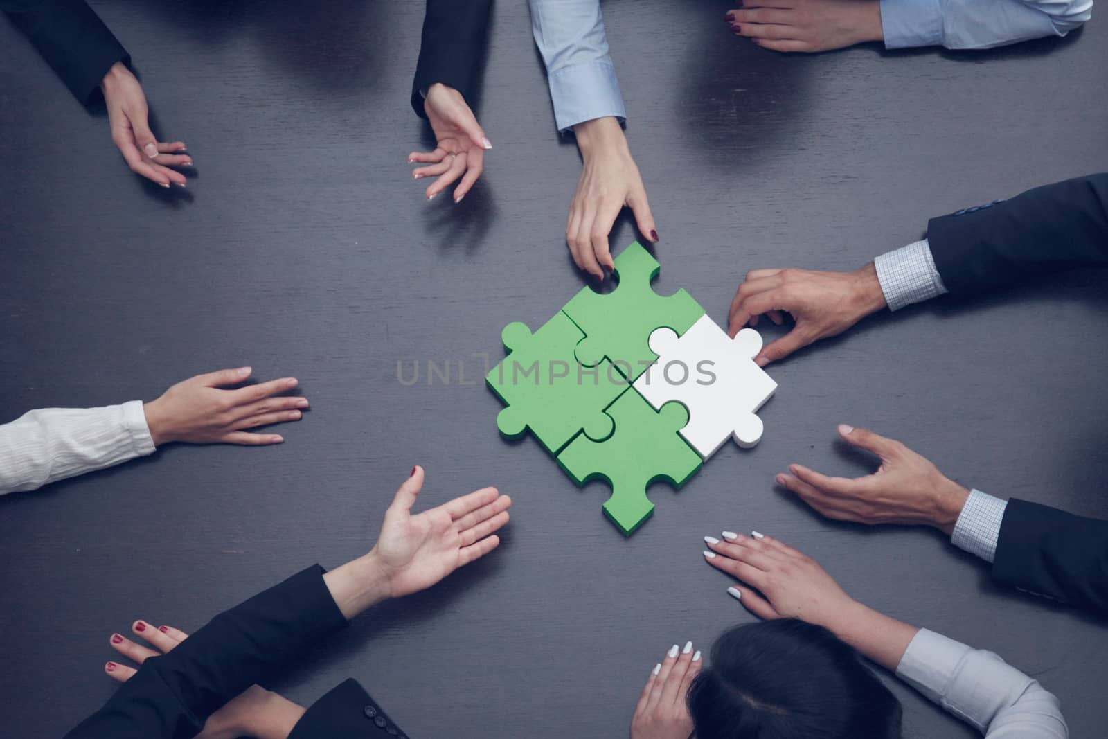 Group of business people assembling jigsaw puzzle, team support and help concept