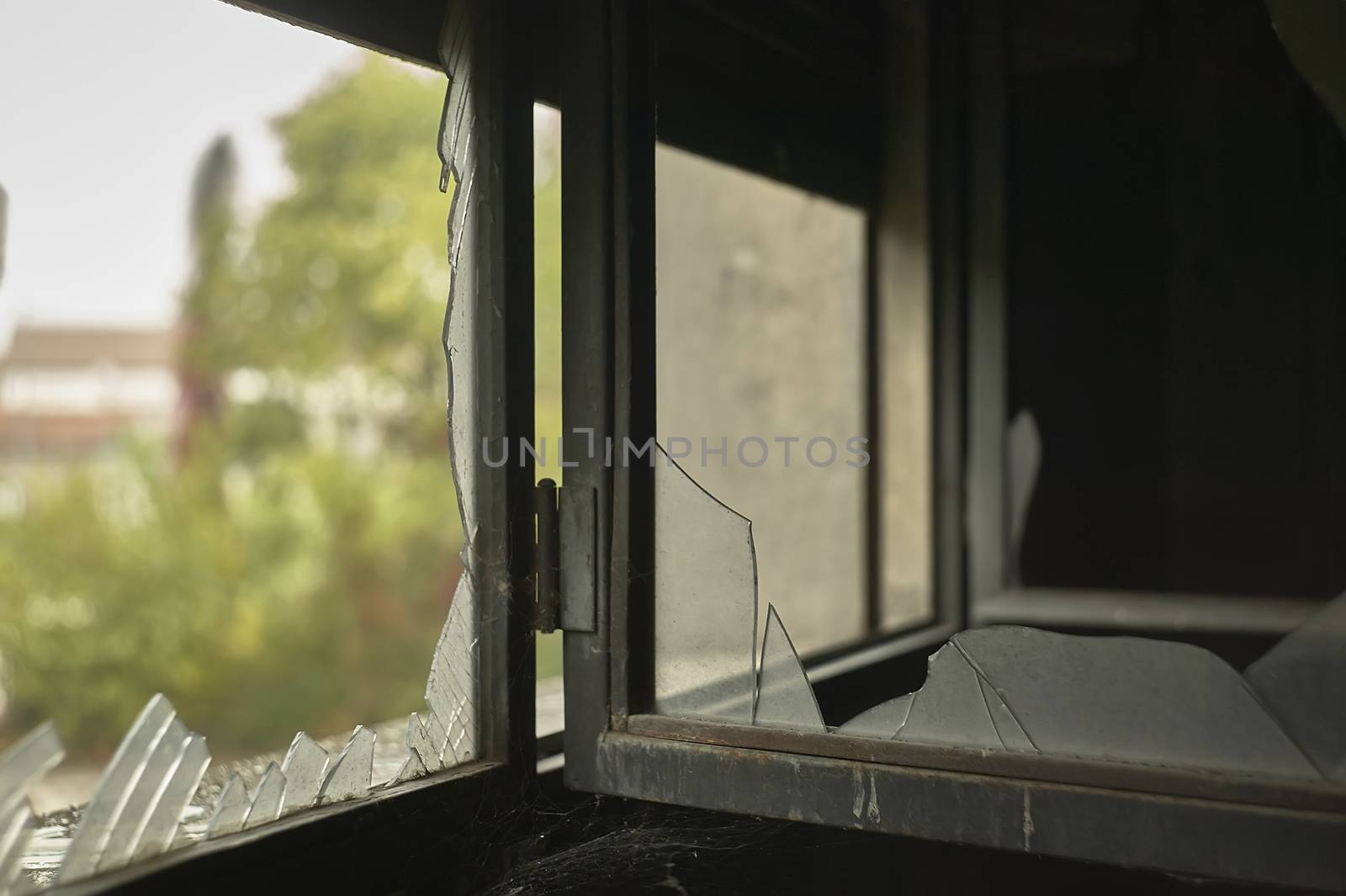 Detail of a broken and ruined window of time and vandals inside an abandoned building.