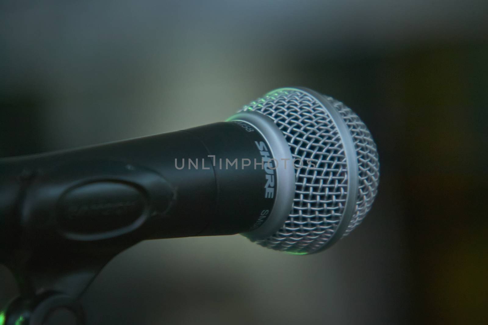 Detail of a microphone for singing taken in front view (view of the singer) with the background completely blurred. Useful as a graphical resource.